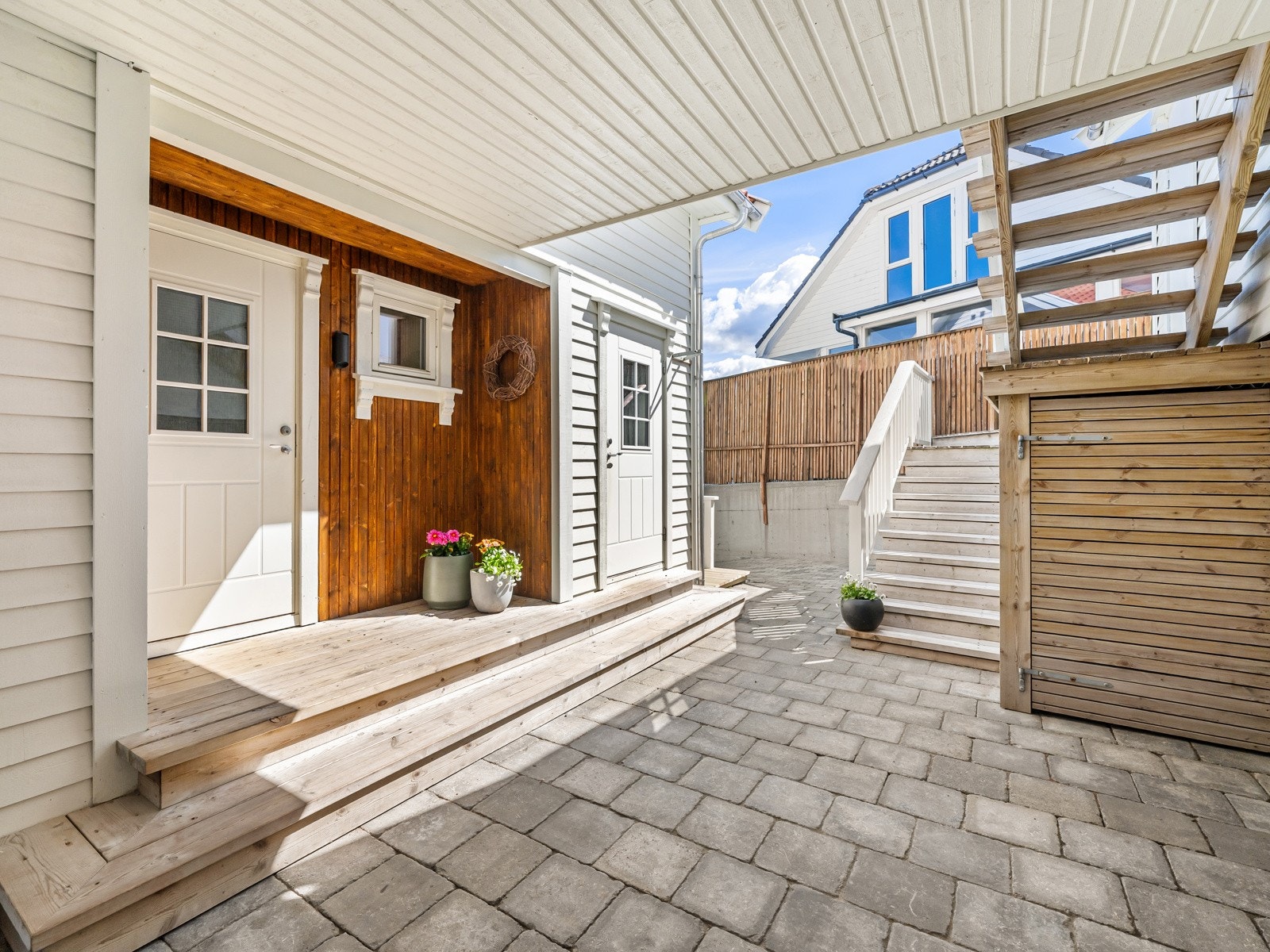 Terrassen som kobler sammen hus og garasje, har også blitt et praktisk overbygg for inngangspartiet til huset, og en kjekk plass som skjermer for vær og vind Galleribilde