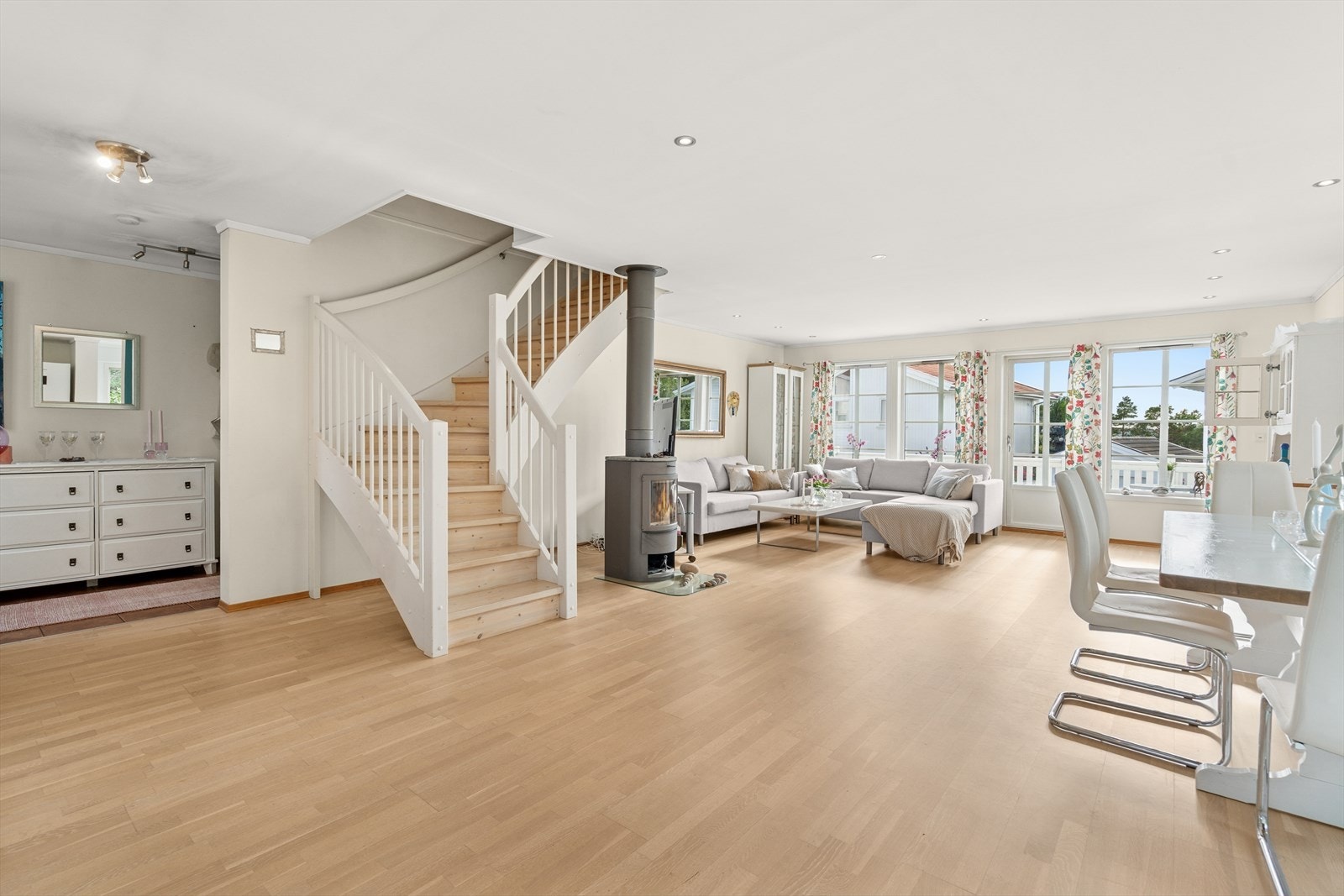 Det er en romslig lekker stue som er naturlig inndelt i ulike brukssoner, bl.a. er det god plass til både sofa og spisestue nærmest kjøkkenet. Galleribilde