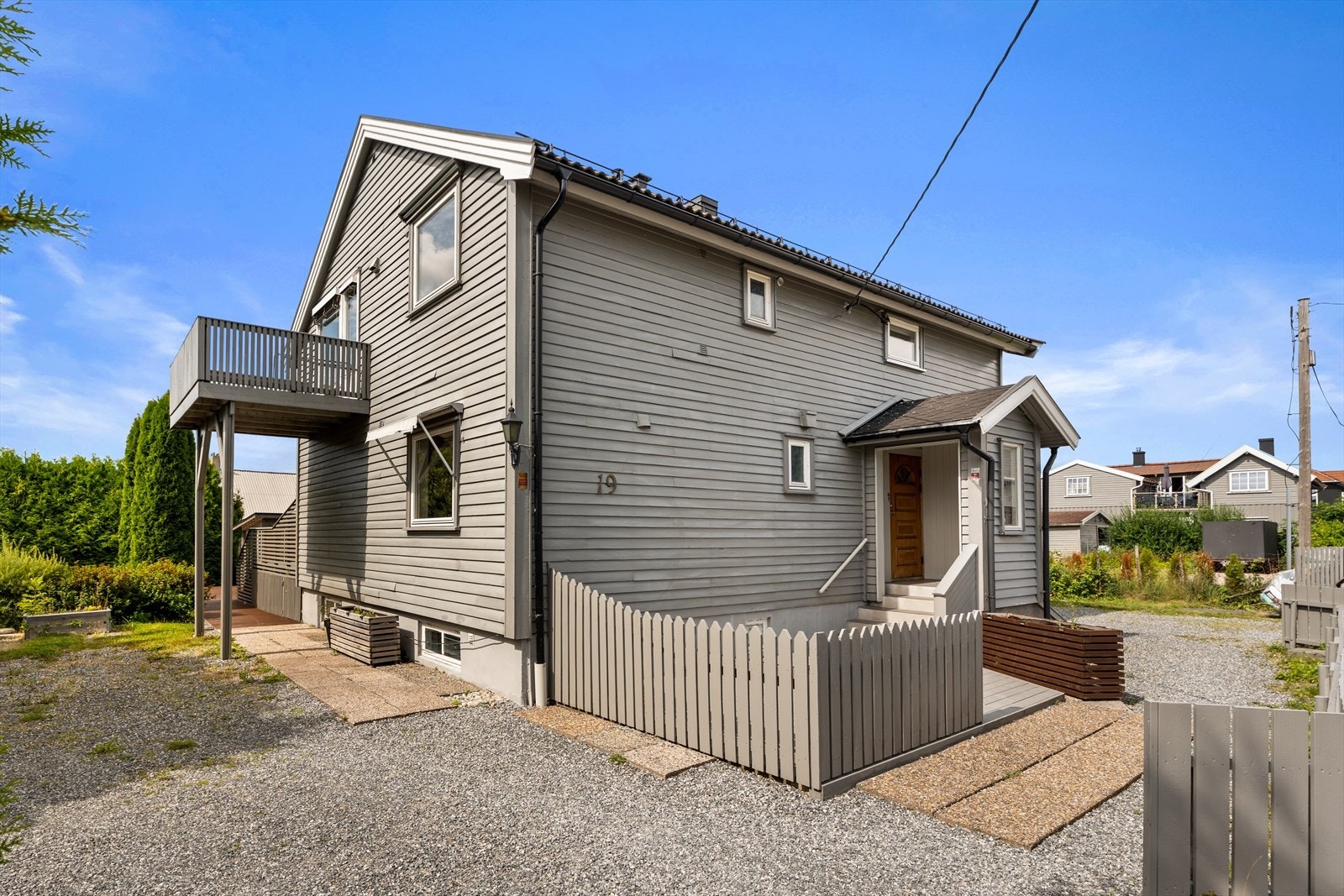 Boligen har adkomst via gruslagt gårdsplass med heller fram til terrasse og trapp opp til inngangspartiet Galleribilde