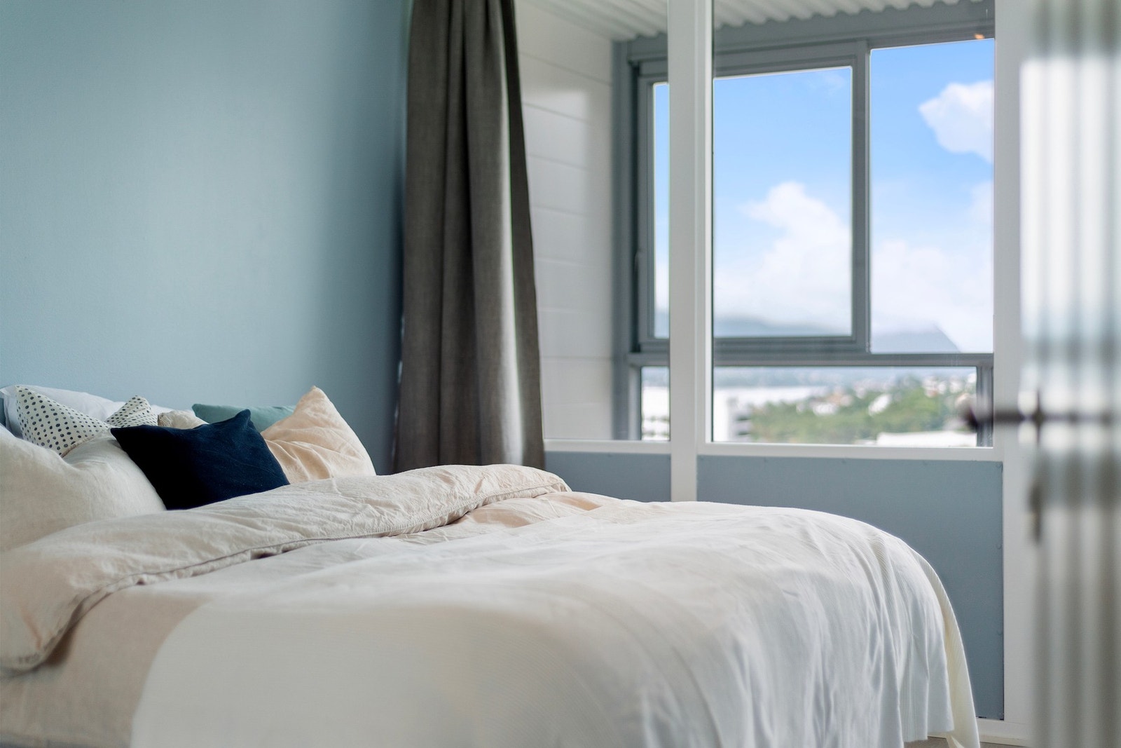 Ute på verandaen er det skyvbare vinduer. Legg også merke til den behagelige og svale nyansen soverommet har på overflater. Galleribilde