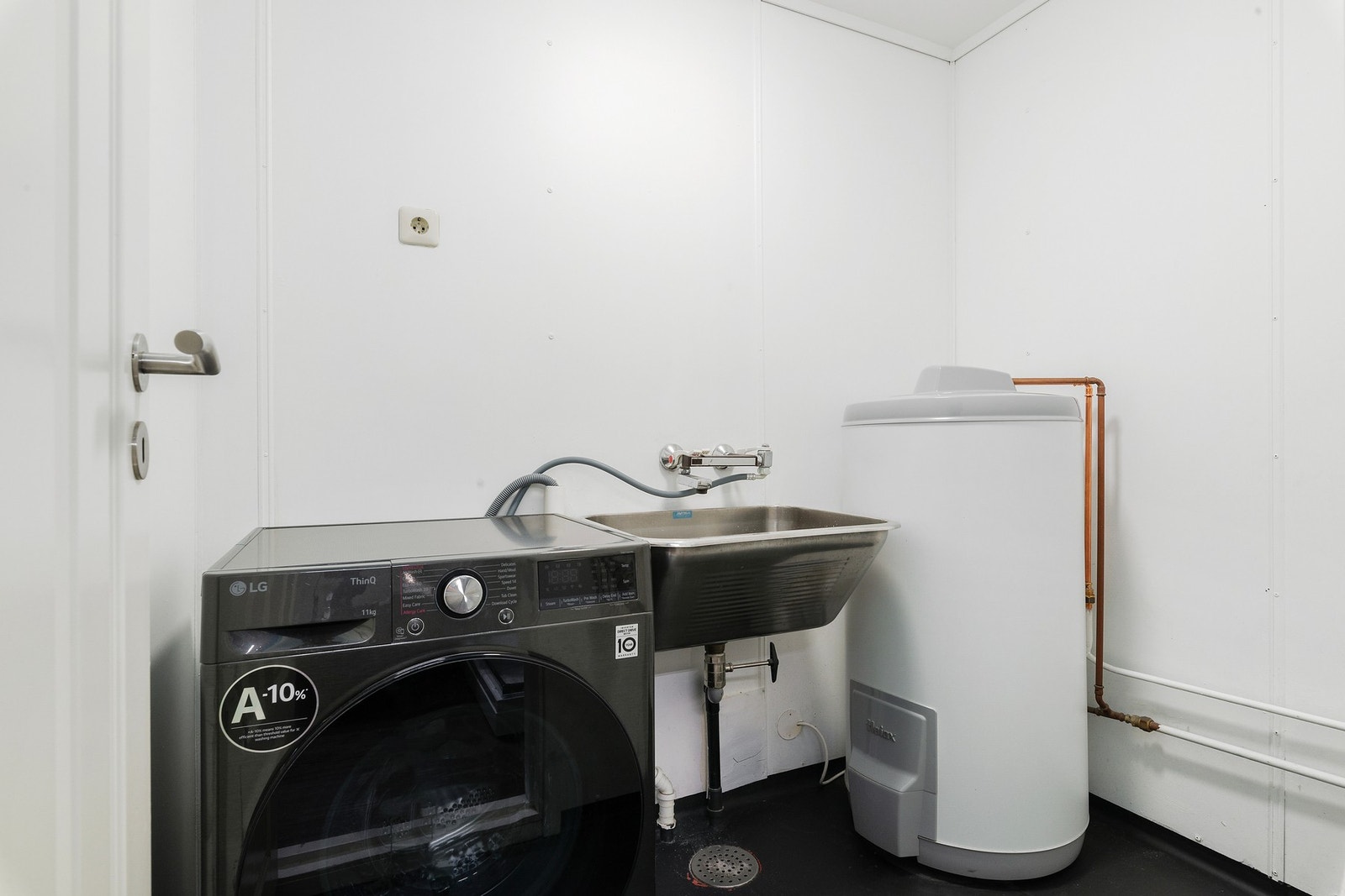 I tilknytning til badet er det eget vaskerom som både har sluk i gulvet, vegghengt skyllekar og varmtvannstank. Galleribilde