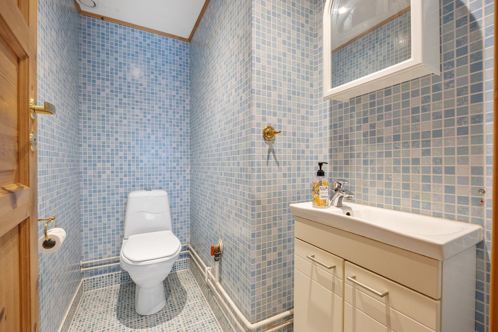 Separat toalettrom med flislagt gulv og servant. Galleribilde