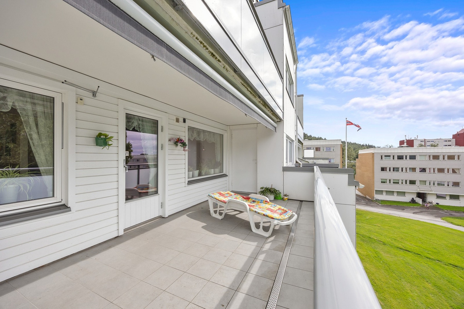 Romslig, vestvendt balkong med flislagt gulv og elektrisk markise. Galleribilde