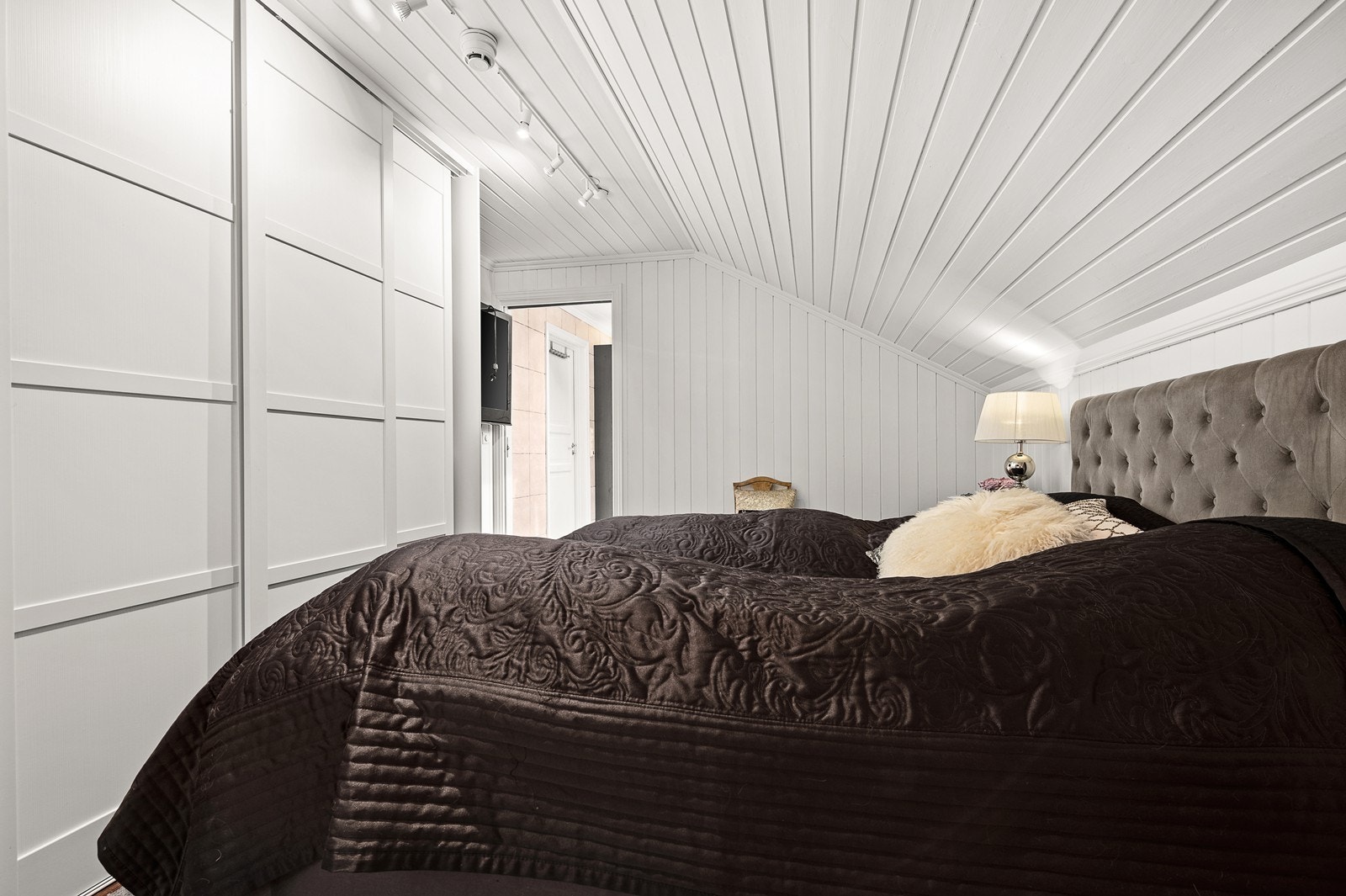 Romslig soverom med skyvedørsgarderobe og direkte inngang til badet. Galleribilde