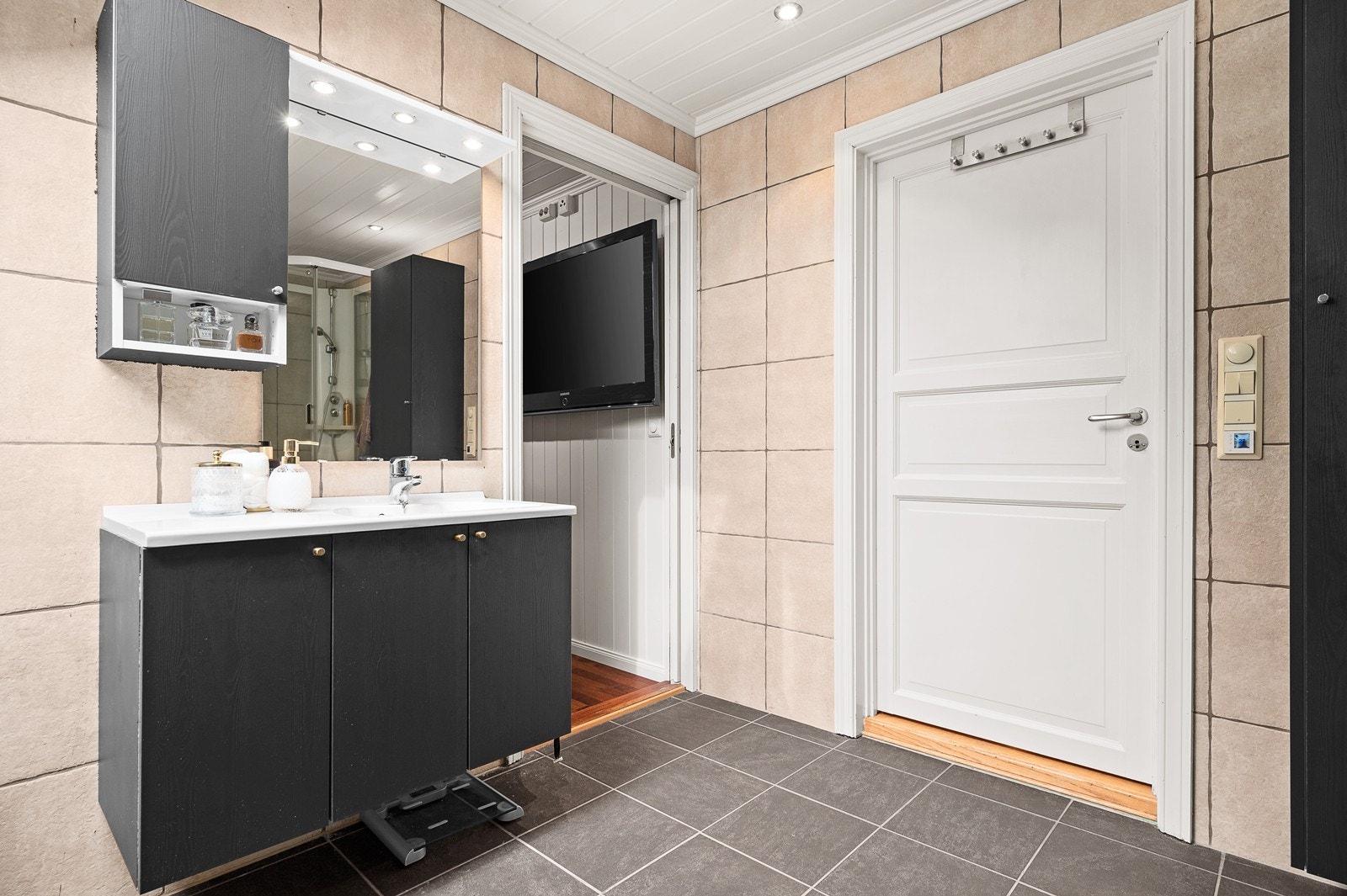 Bad med wc, dusjkabinett, hjørnebadekar og håndvask med speilskap. Galleribilde