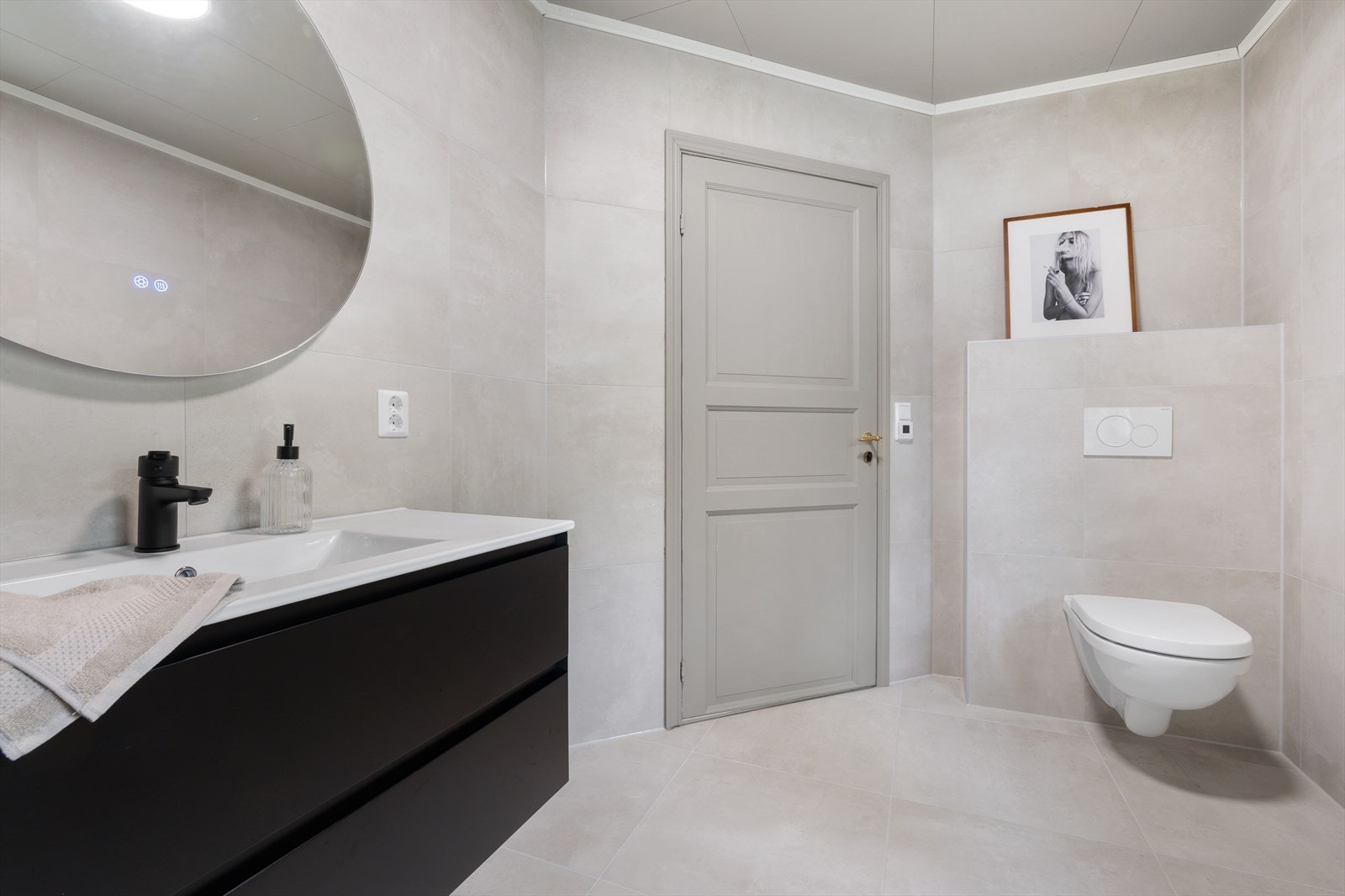 Badet er innredet med nedfelt servant, veggmontert toalett og dusjkabinett. Galleribilde