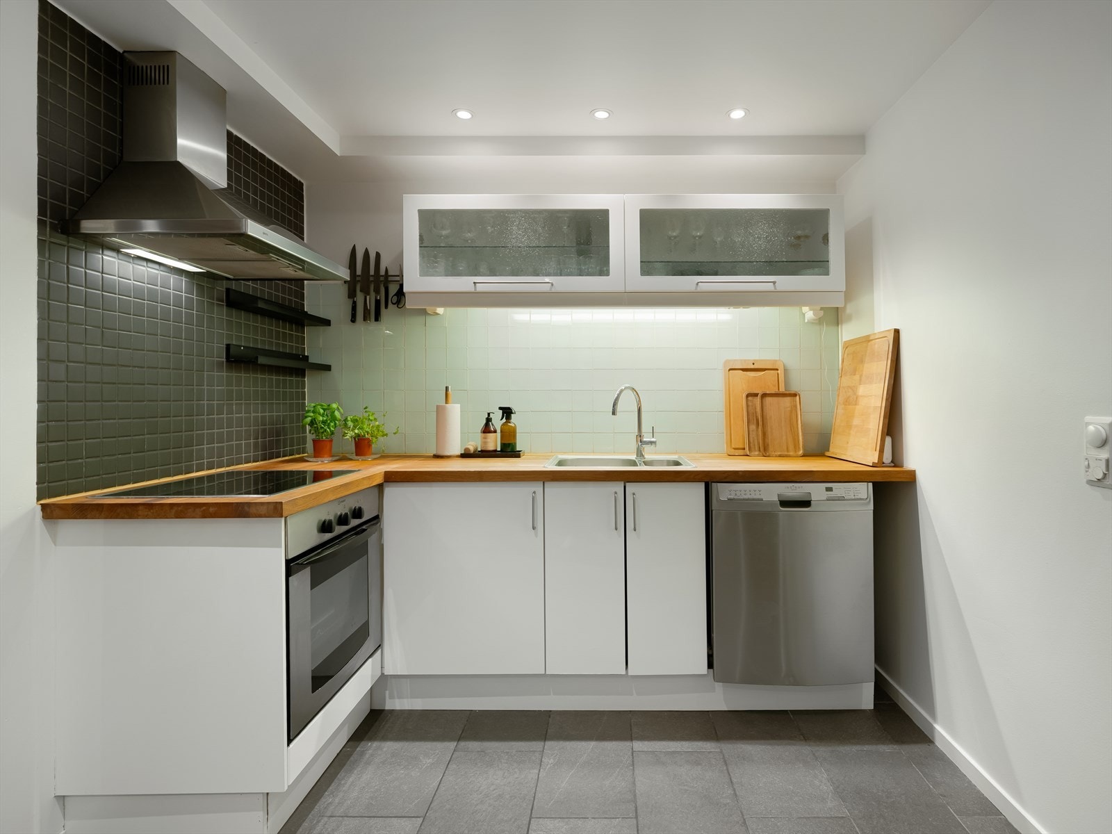 De lyse frontene sammen med den heltre benkeplaten og fliser i benkerygg gir kjøkkenet et stilrent og tidløst uttrykk. Galleribilde