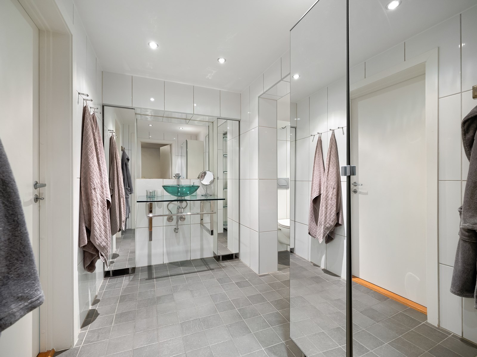 Baderommet er både romslig og stilfullt, med moderne baderomsmøbler som gir et rent og pent uttrykk. Galleribilde