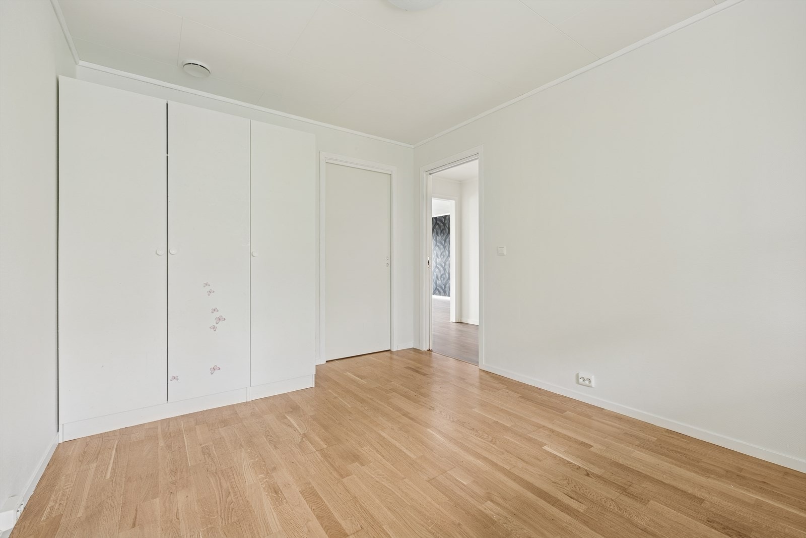 Videre byr leiligheten på to soverom. På det ene soverommet er det montert garderobeskap med god plass til oppbevaring. Dette er soverom 1. Galleribilde
