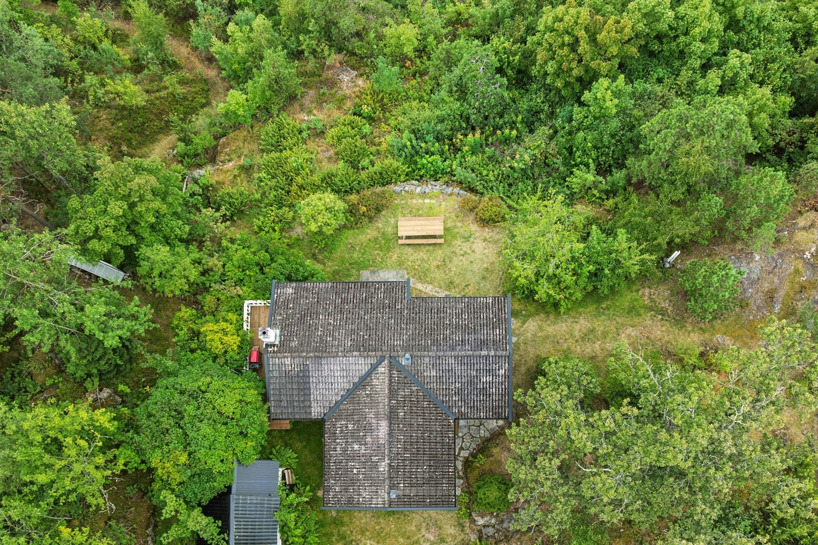 Dronebildet viser hvordan hytta smelter inn i landskapet, som byr på både privatliv og naturopplevelser. Galleribilde