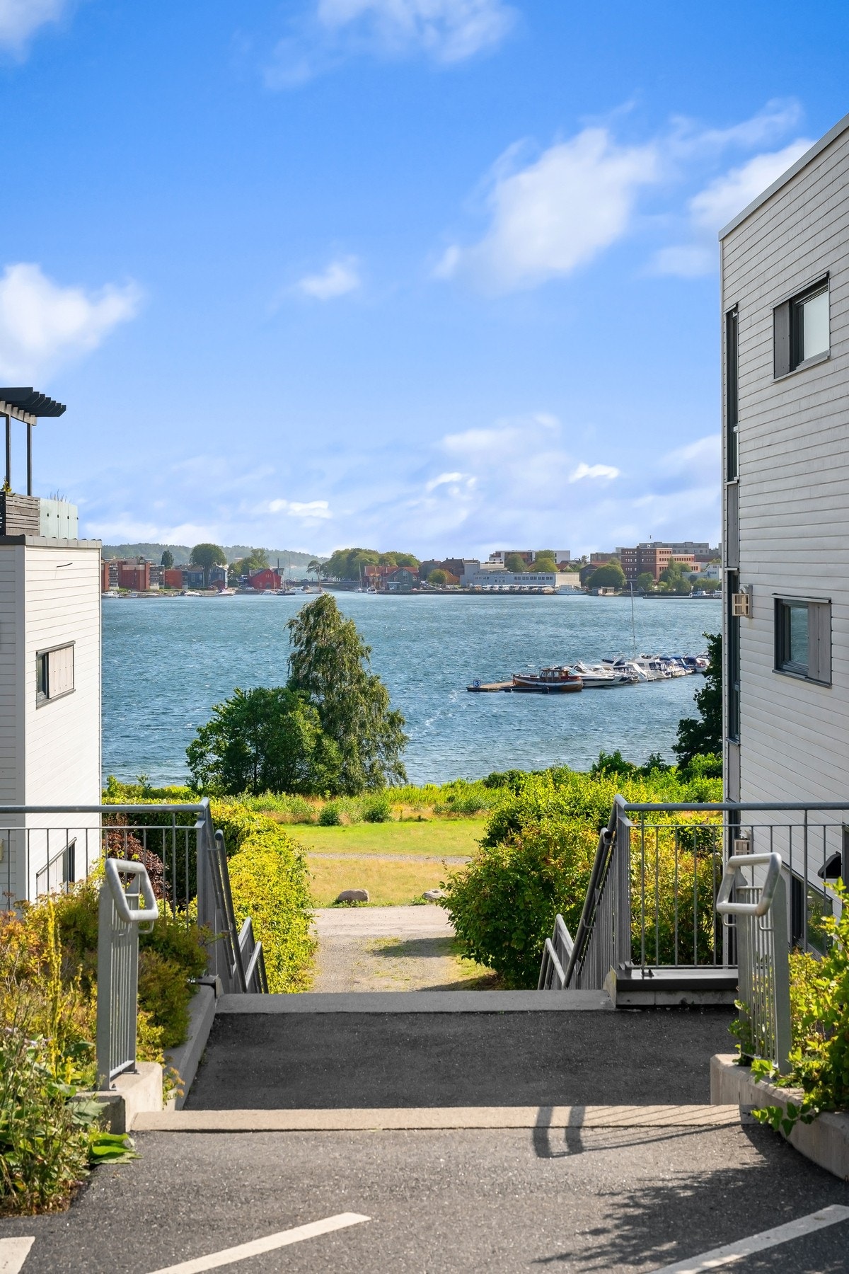 Tomten er pent opparbeidet med plen, diverse beplantning og asfalterte gangveier Galleribilde