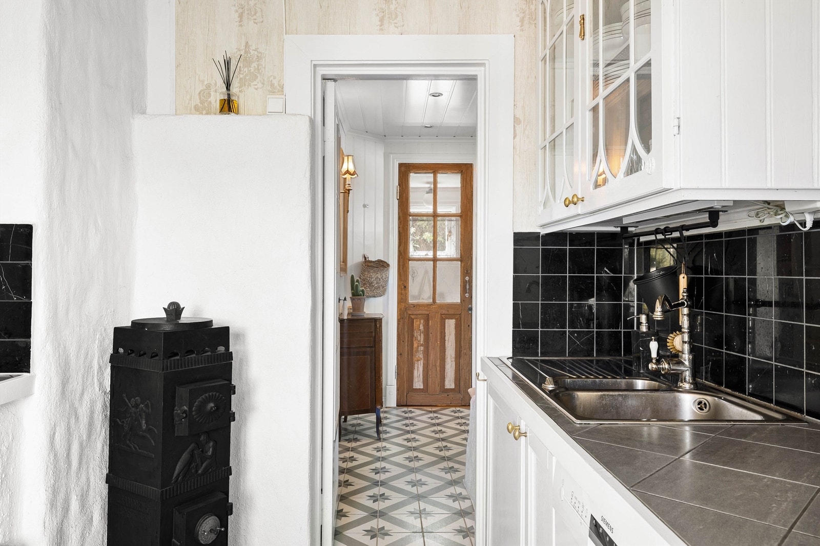 I det klassiske kjøkkenet er det plassert en ovn som utfyller de sjarmerende detaljene, samt tilbyr varme på kalde dager. Galleribilde