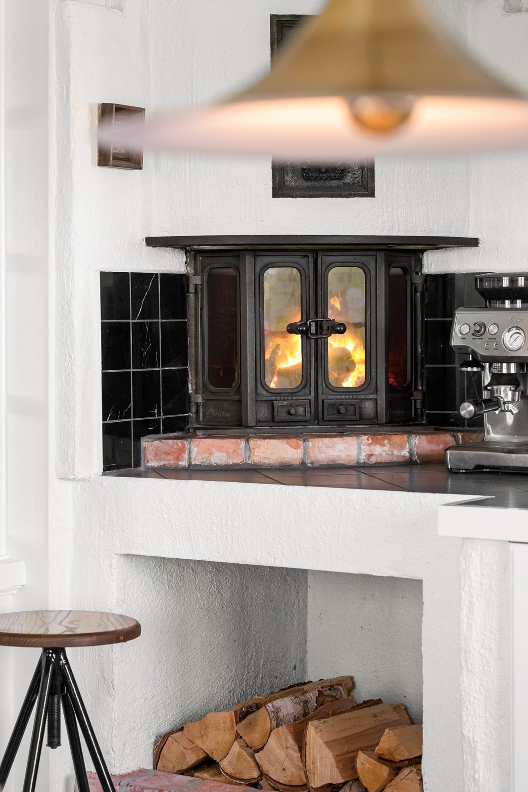 Vakker og stemningsfull peis med vednisje - gir både varme og karakter til kjøkkenet. Galleribilde