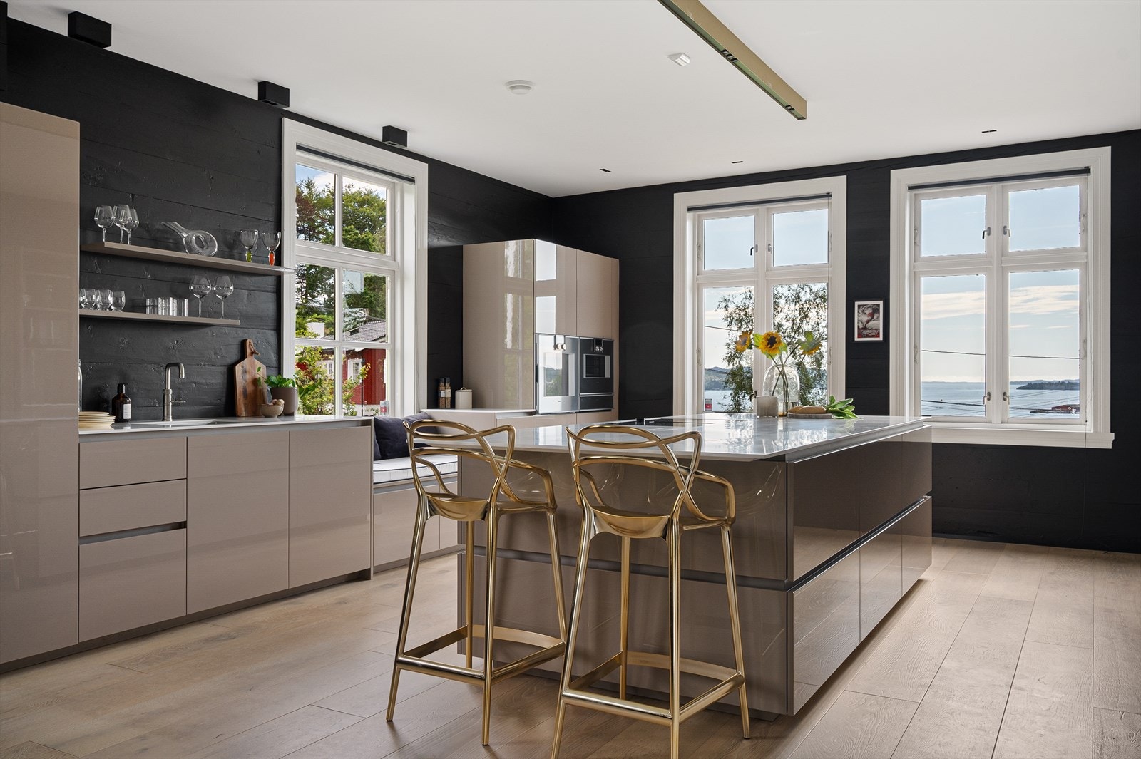 Mye arbeidsrom med kjøkkenøy i midten. Nedfelt platetopp i nivå med den rålekre benkeplaten. Galleribilde