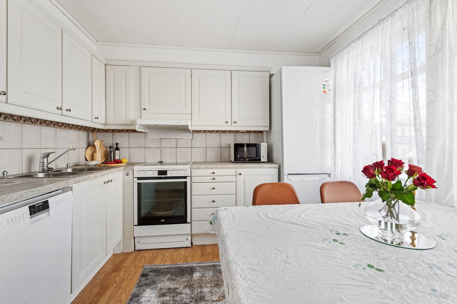 Kjøkkeninnredning fra byggeår med frittstående hvitevarer. Galleribilde