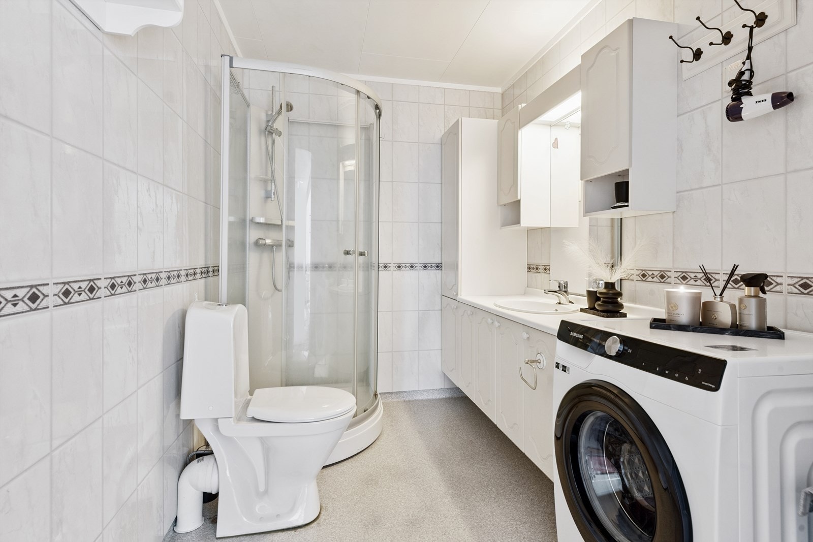 Bad/vaskerom med vinylbelegg med varme på gulv, våtromsplater på vegger og tak-ess i tak. Galleribilde