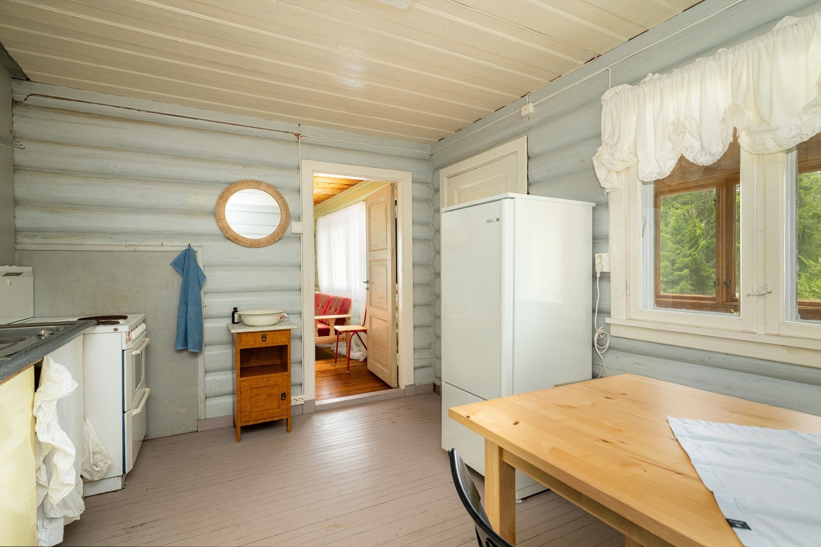 Kjøkkenet er malt i lyse, svale fargetoner og har innredning antatt fra byggeår. Malte, glatte fronter på innredning og laminat benkeplate med nedfelt benkebeslag med oppvaskkum, skyllekum og avrenningsflate. Galleribilde