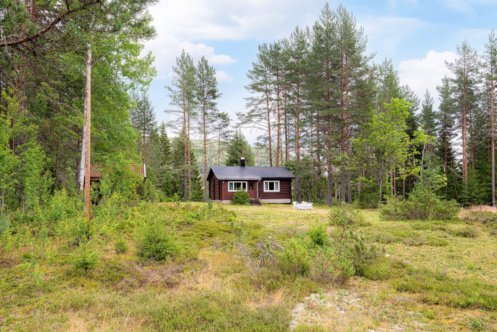 Koselig hyttetun med fritidsbolig, stabbur og uthus langs med Tinnåa i Gransherad i Notodden kommune. Galleribilde