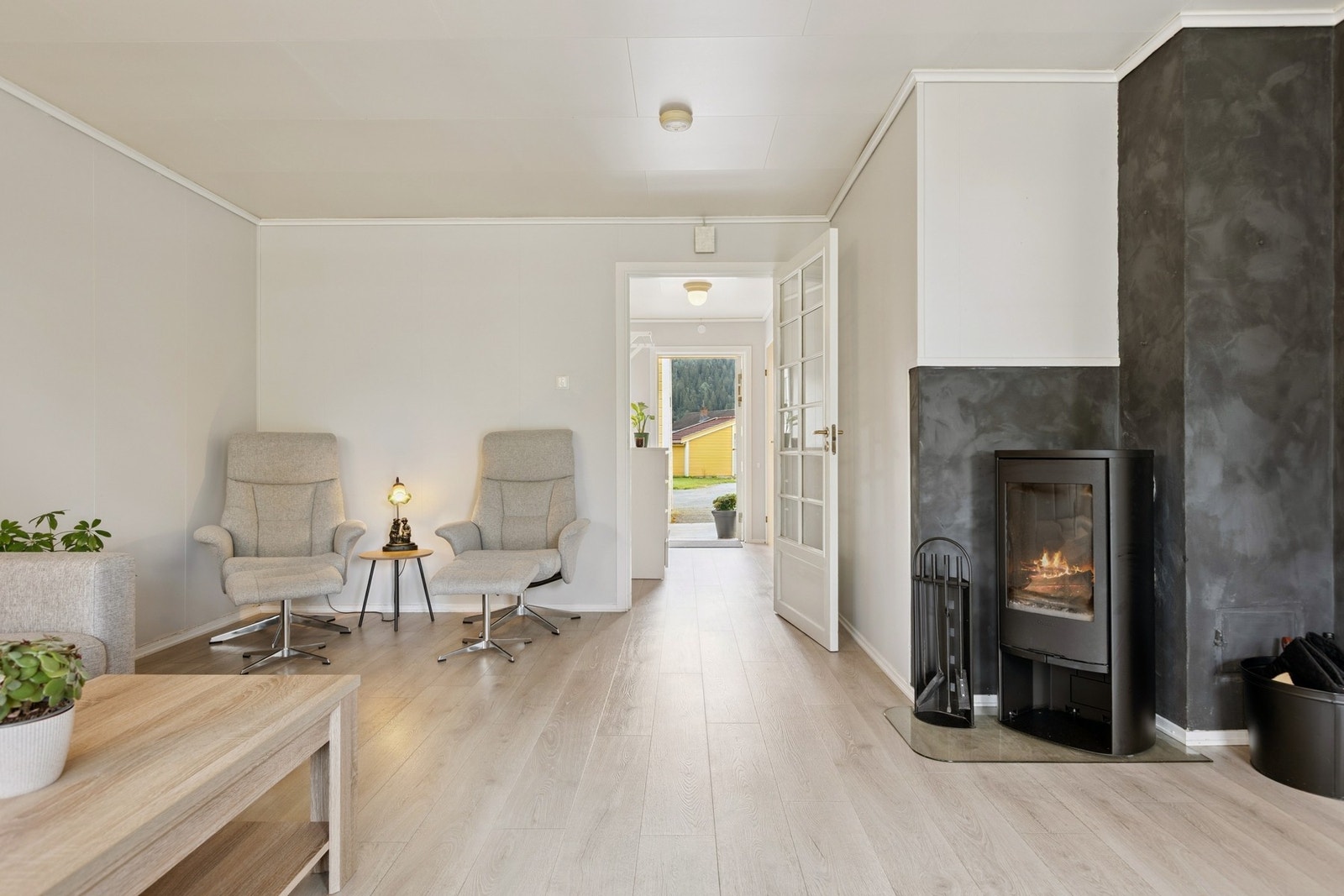 Stuen har vedfyring med ny vedovn fra 2024, og det plass til både sofaløsning, sittegruppe og et større spisebord. Galleribilde