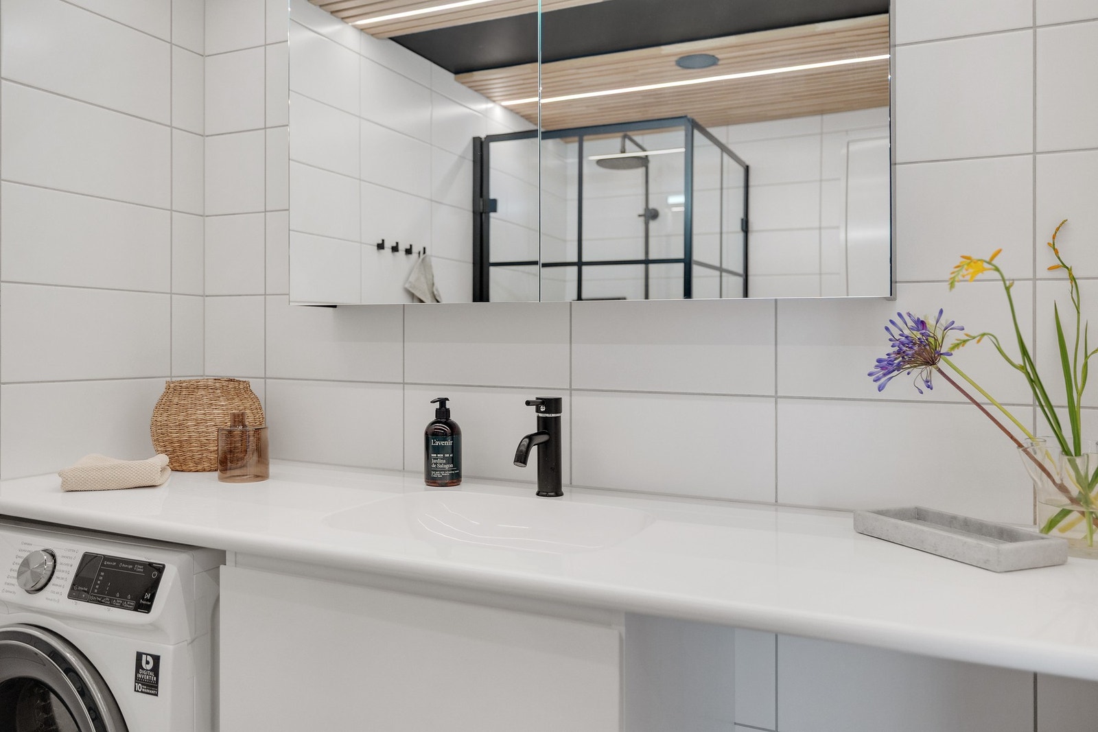 Badet har heldekkende benkeplate med servant, skuffer under, speilskap med lys, vegghengt toalett og opplegg for vaskemaskin. Galleribilde