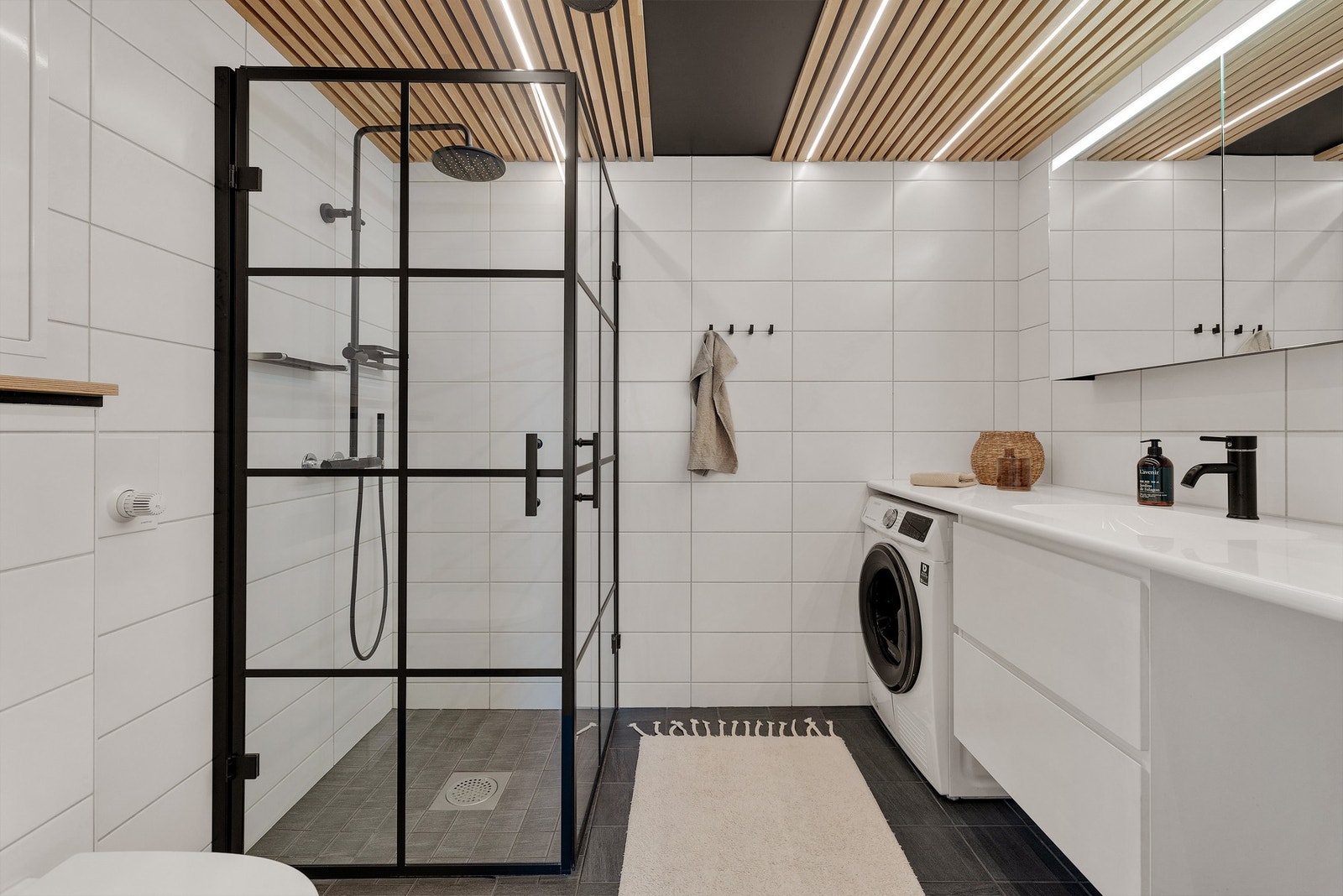 Hovedbadet er lekkert innredet med mørke gulvfliser, lyse veggfliser og nedforet himling med stålplater, eikespiler og ledbelysning. Gulvet har vannbåren varme. Galleribilde