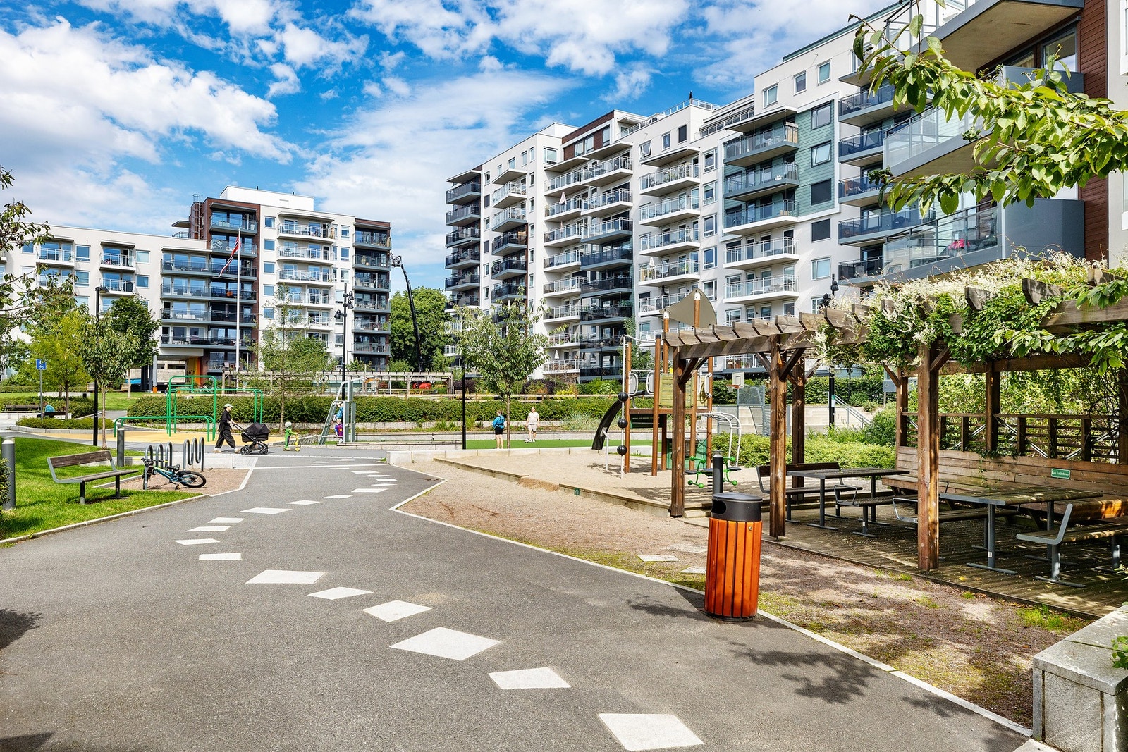 Velstelt gressplen, gangveier, beplantning, sittegrupper og lekeplass for de små. Galleribilde