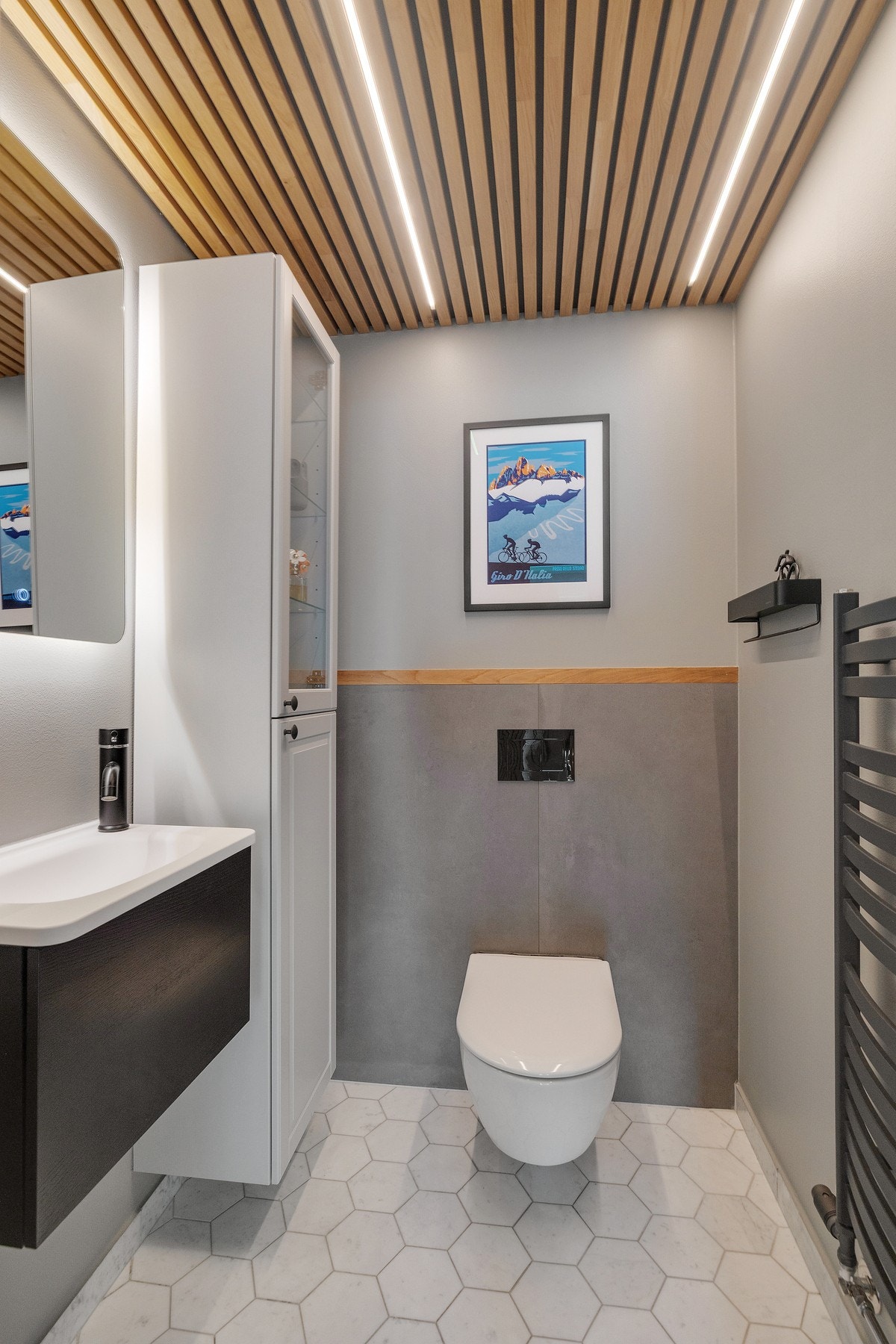 Det separate toalettrom har flislagt gulv, malte veggflater med eikespiler, servant med sort ettgrepskran og skap under, speil med lys, høyskap, vegghengt toalett og vannvarmet håndkletørker. Galleribilde