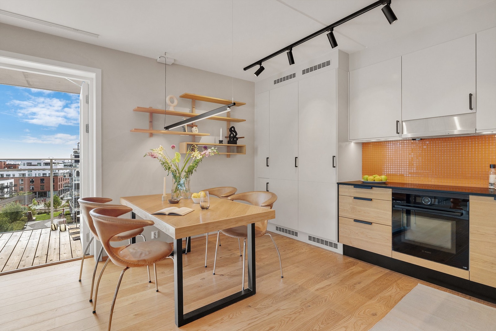 Mellom benk og overskap er det fliser, stikkontakter og ledbelysning. Hvitevarene er integrerte. Galleribilde