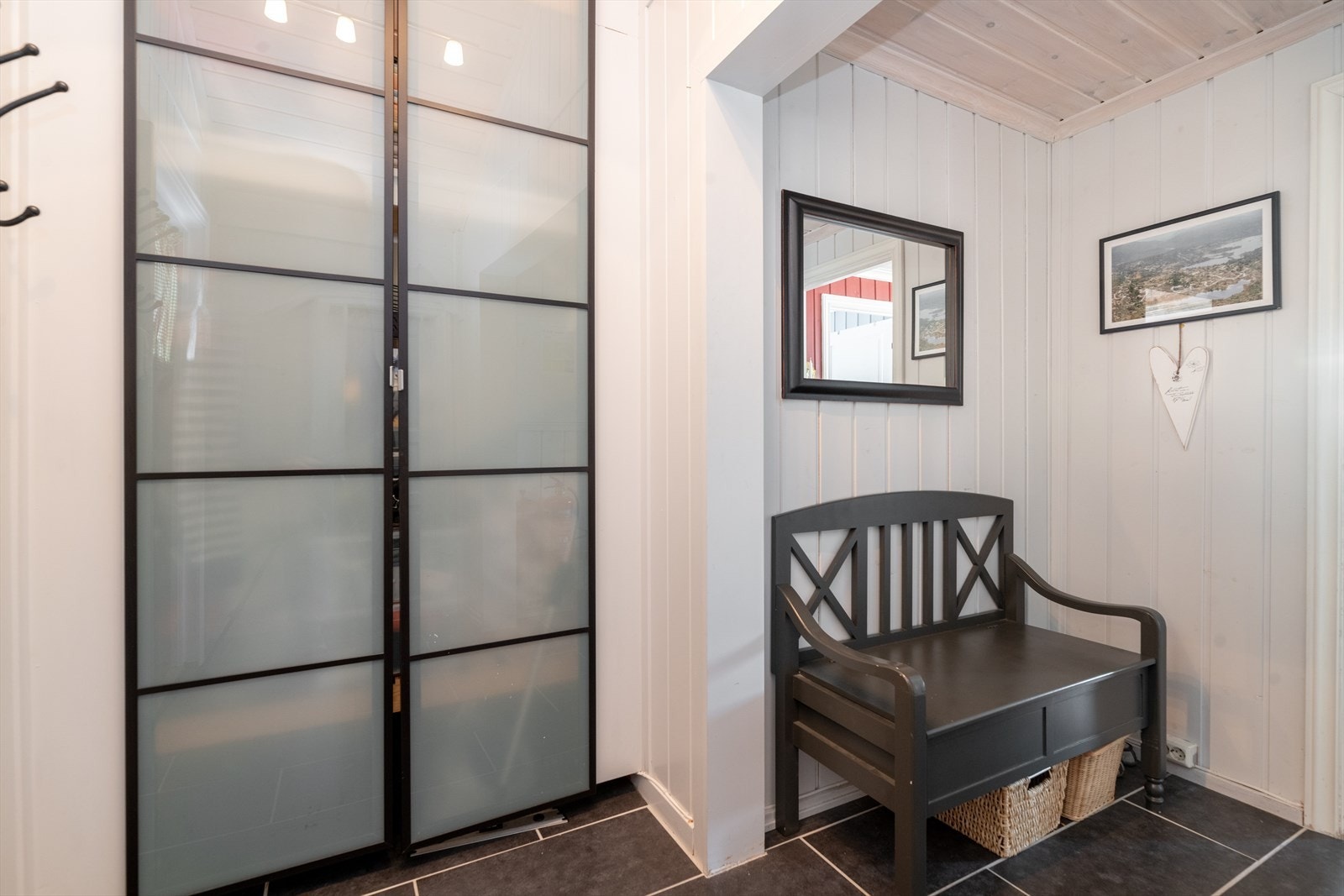 Lys og romslig entré/gang med flislagt gulv og praktisk garderobeskap, samt tilliggende romslig bod med innvendig adkomst. Galleribilde