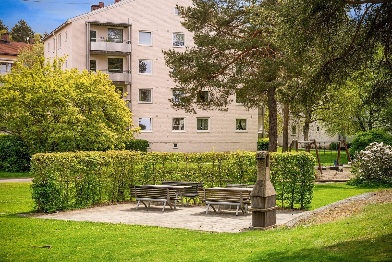 Fin naturtomt rundt bygget med flere felles sitteplasser. Galleribilde