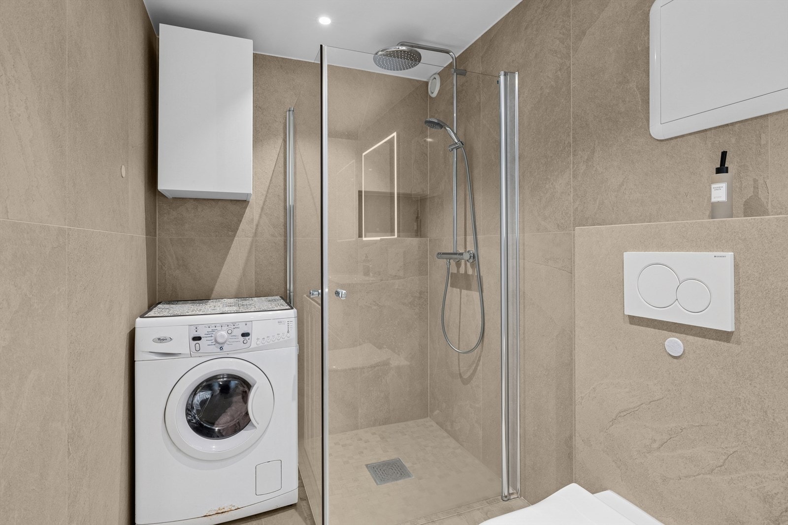 Her finner du vegghengt toalett, stilren servant og et praktisk dusjhjørne. Det er opplegg for vaskemaskin, og mekanisk avtrekk sørger for god ventilasjon og et friskt inneklima. Galleribilde