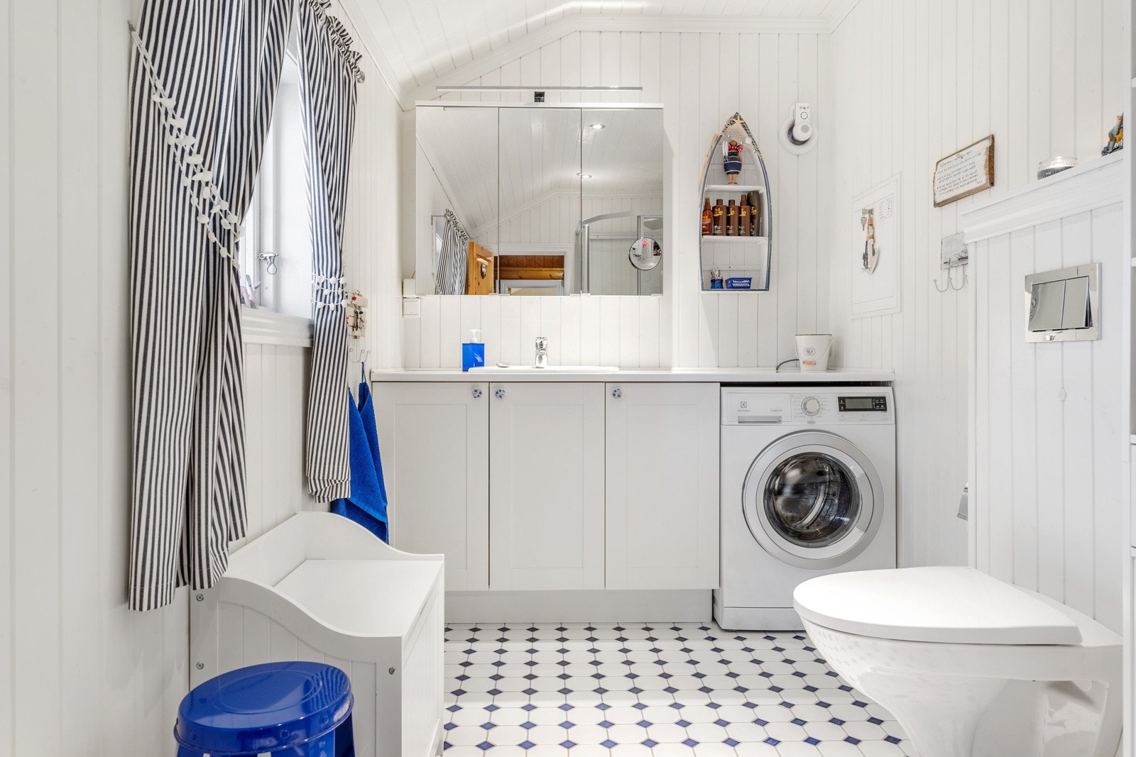 Nyerer romslig bad med skap, benkeplass og vaskemaskin Galleribilde