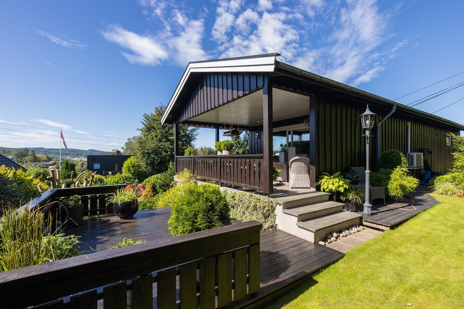 Terrasseplatting og stor overbygget terrasse med utgang fra stue Galleribilde