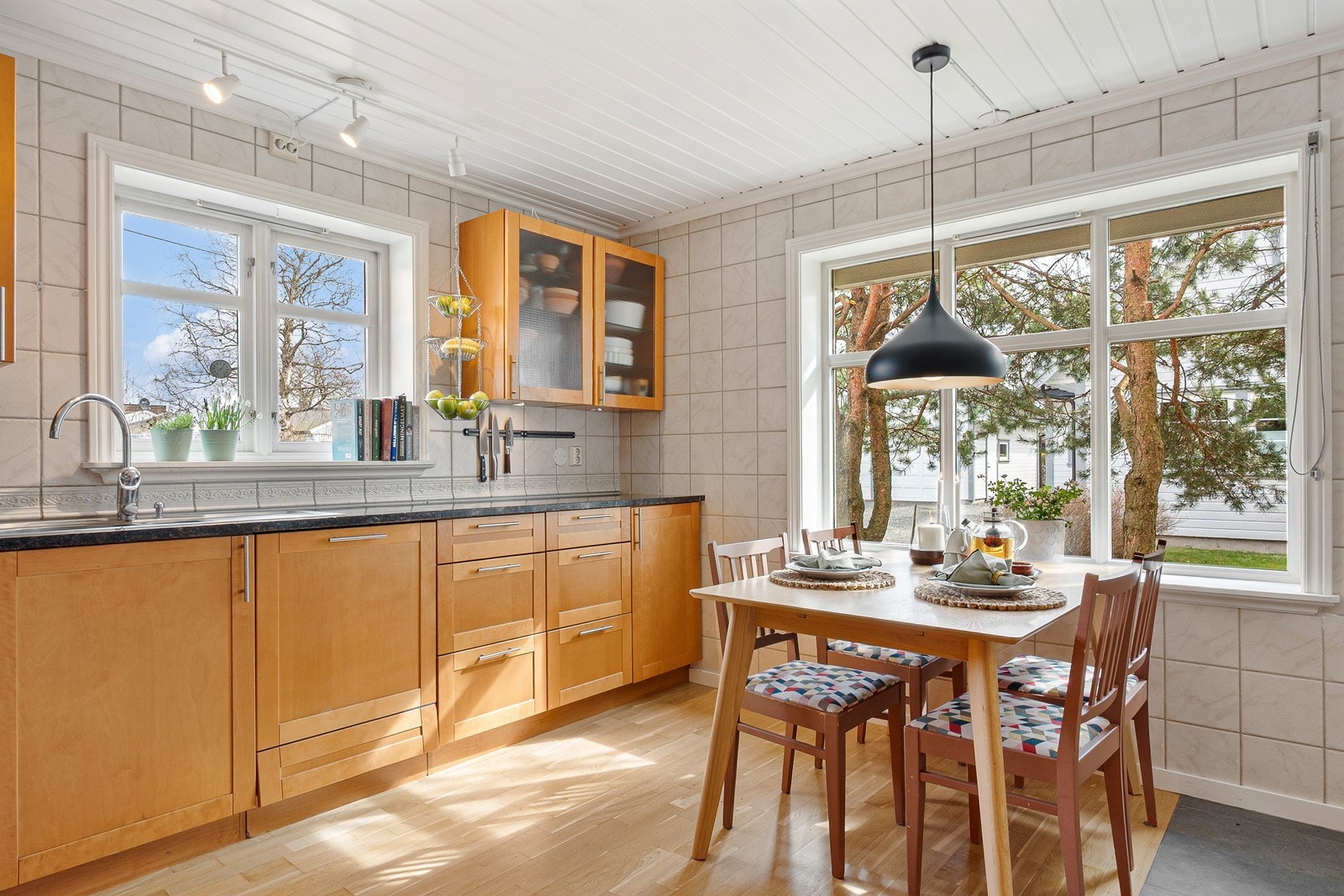 Ved stort vindu har kjøkkenrommet plass til frokostbord med utsyn mot hagen. Galleribilde