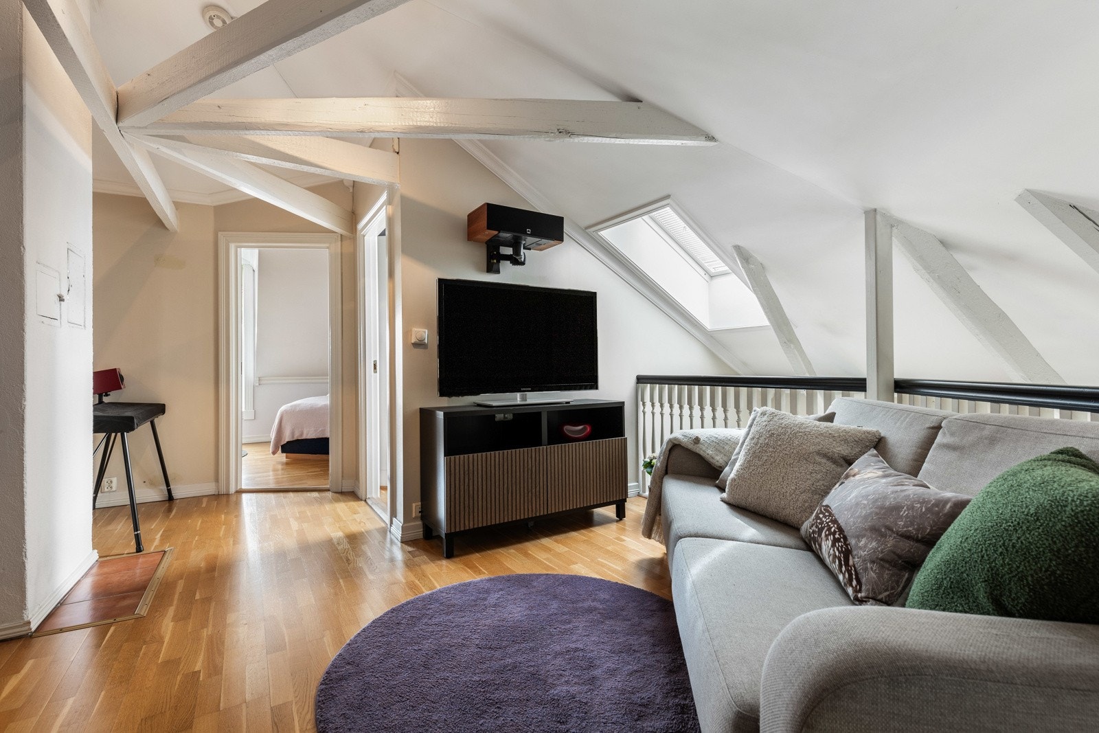 Gulvet har parkett, og både himling og rekkverk er hvitmalt, mens øvrige overflater er beige. Galleribilde