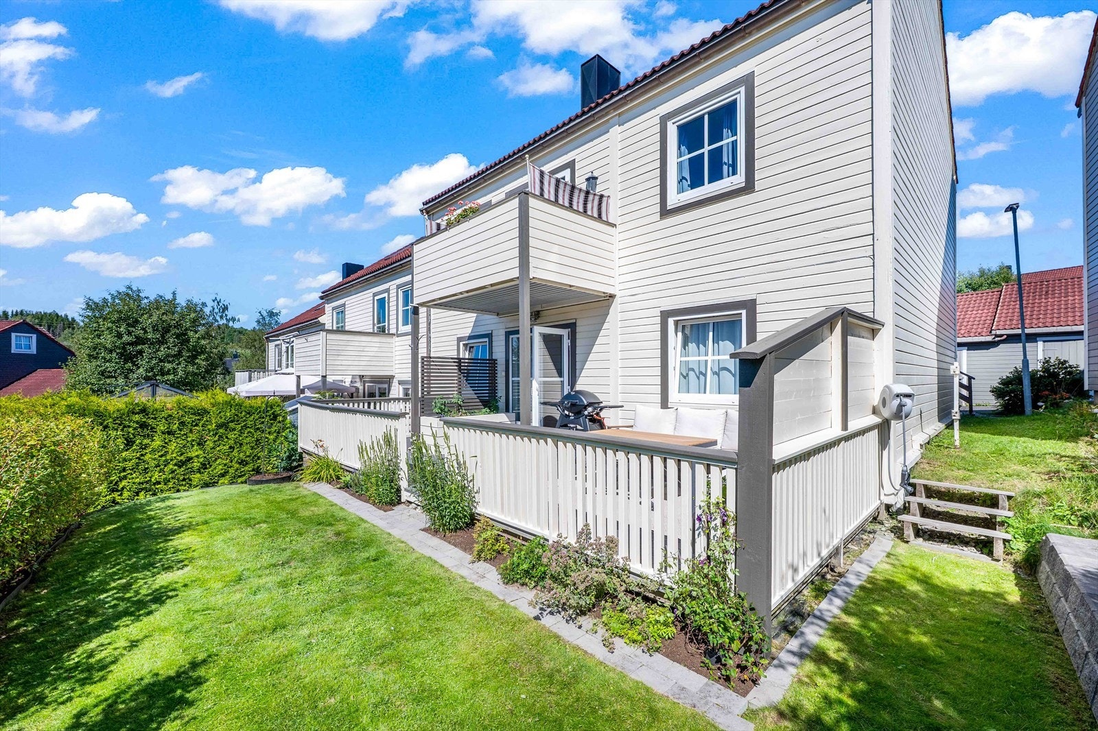 Sjarmerende uteområde med plen og beplantning. Galleribilde