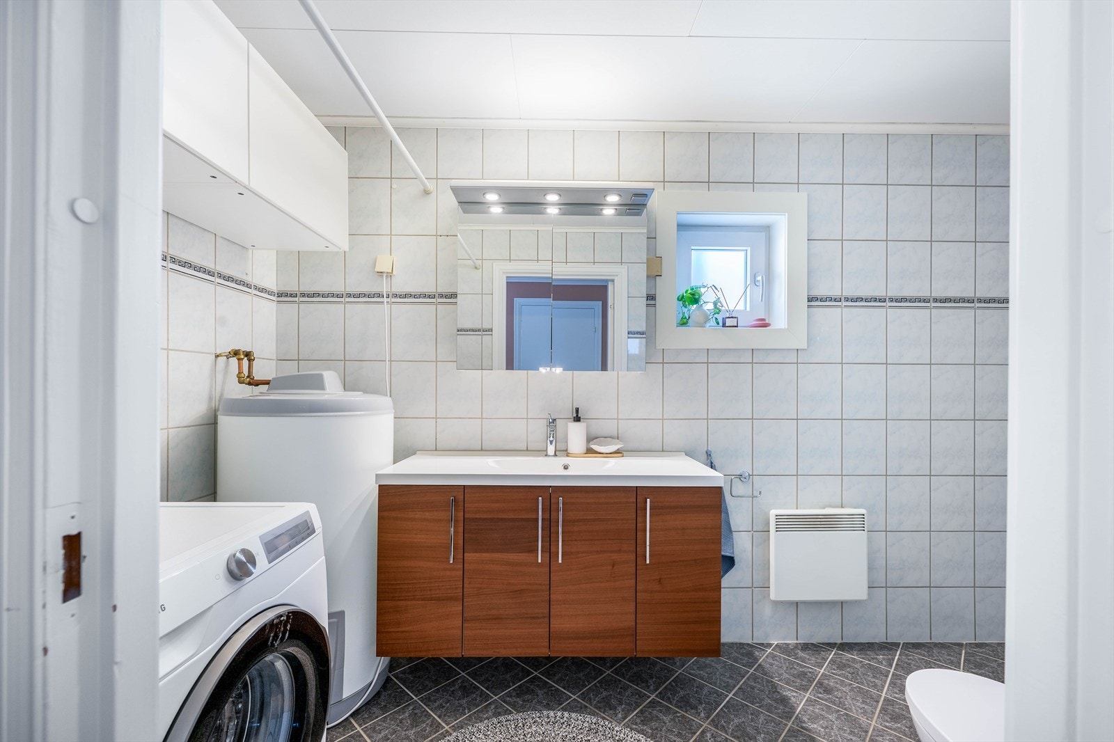 Bad med opplegg for vaskemaskin og god oppbevaringsplass. Galleribilde