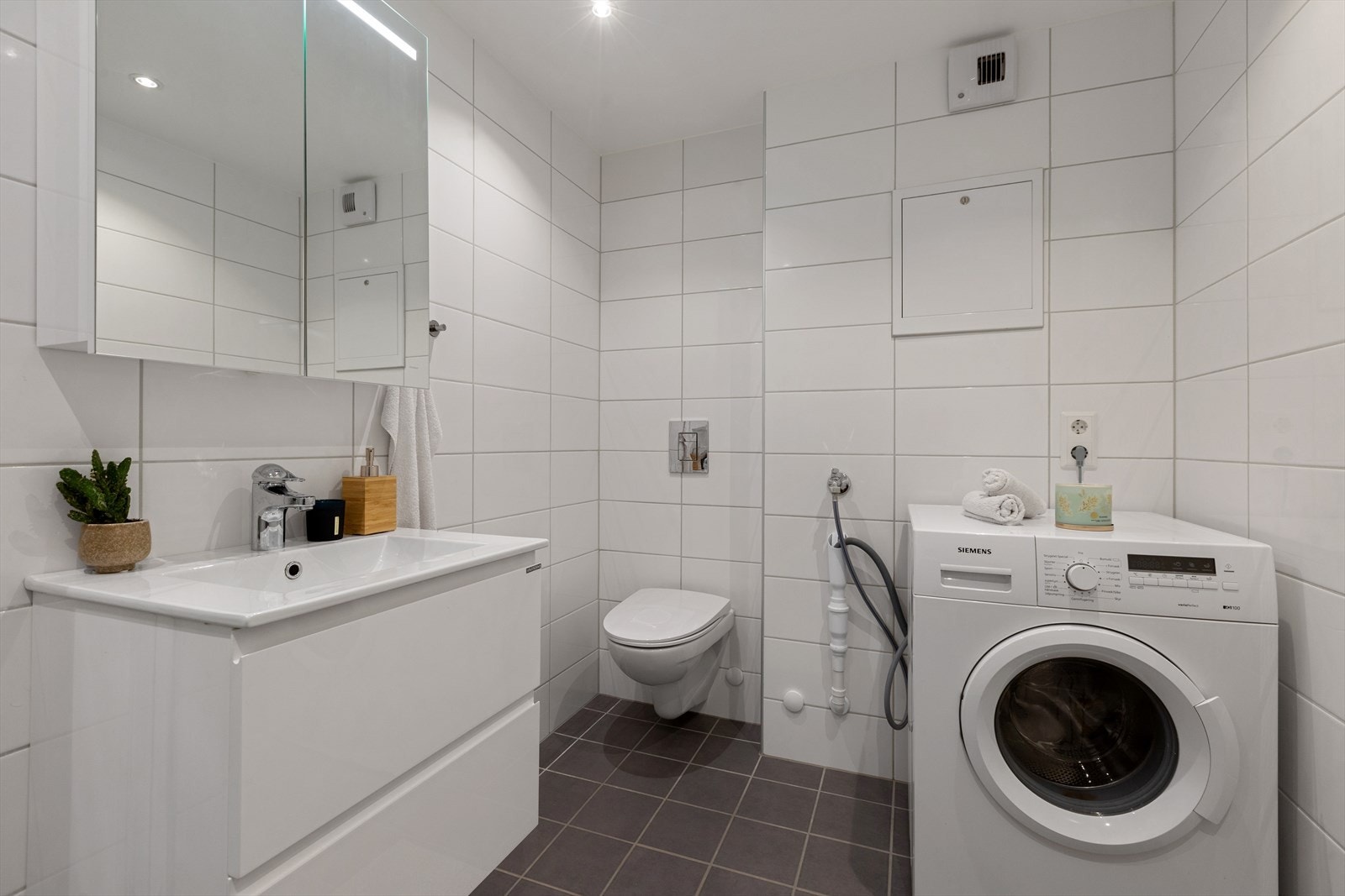 Bad med vegghengt wc og uttak til vaskemaskin Galleribilde