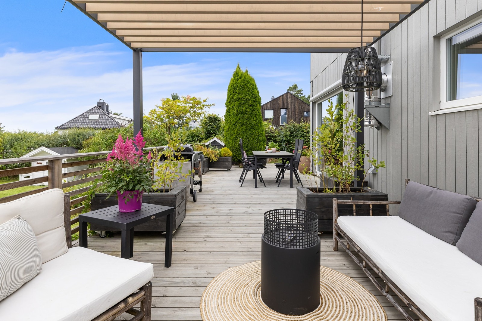 En del av terrassen er utstyrt med en stilfull pergola som gir en lun atmosfære, perfekt for lange sommermiddager. Galleribilde