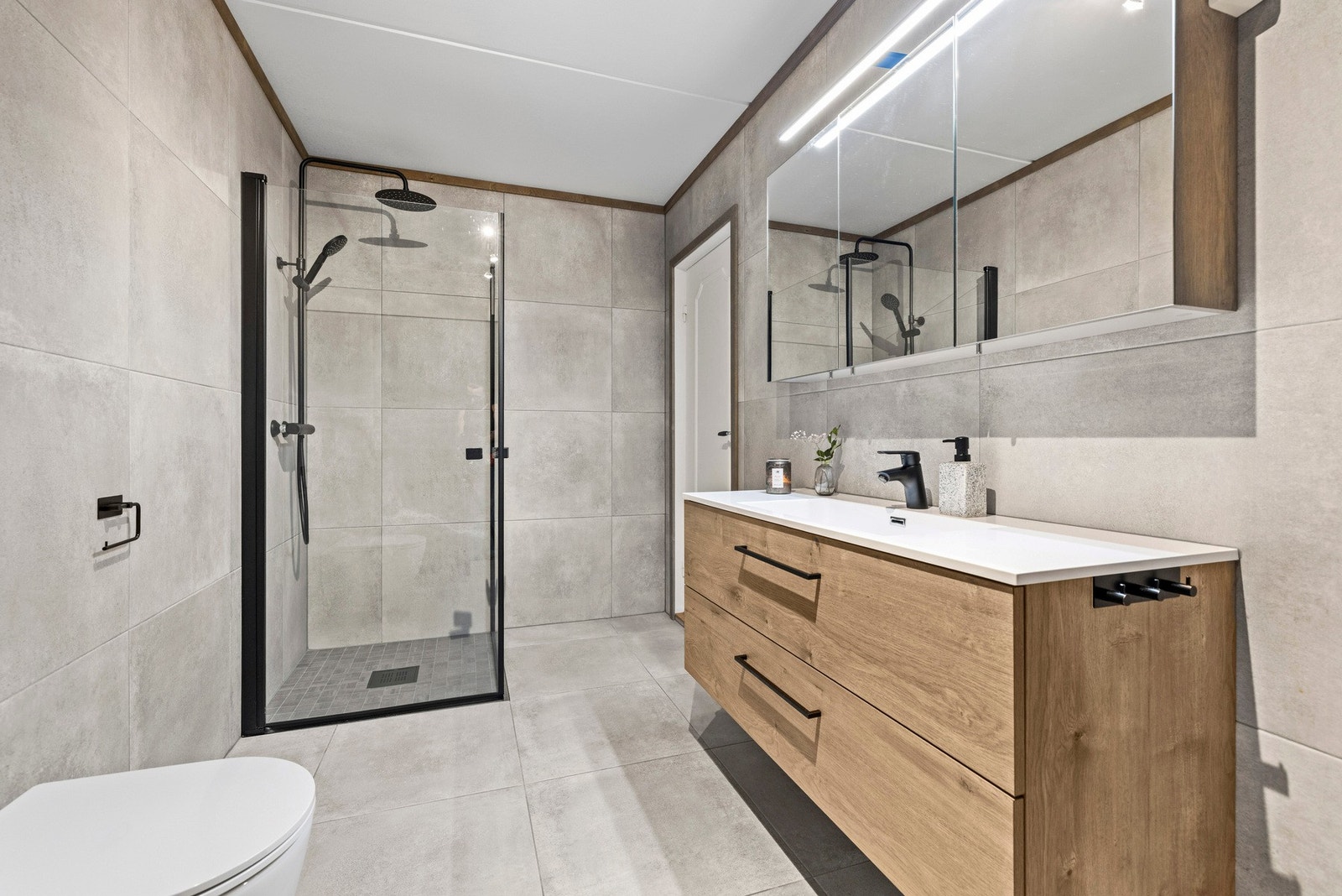 Badet ble pusset opp av fagfolk i 2022, og her får du en romslig løsning med både god dusjplass, vegghengt toalett og en egen vaskeromsavdeling med opplegg for vaskemaskin - praktisk og veldig behagelig i hverdagen. Galleribilde