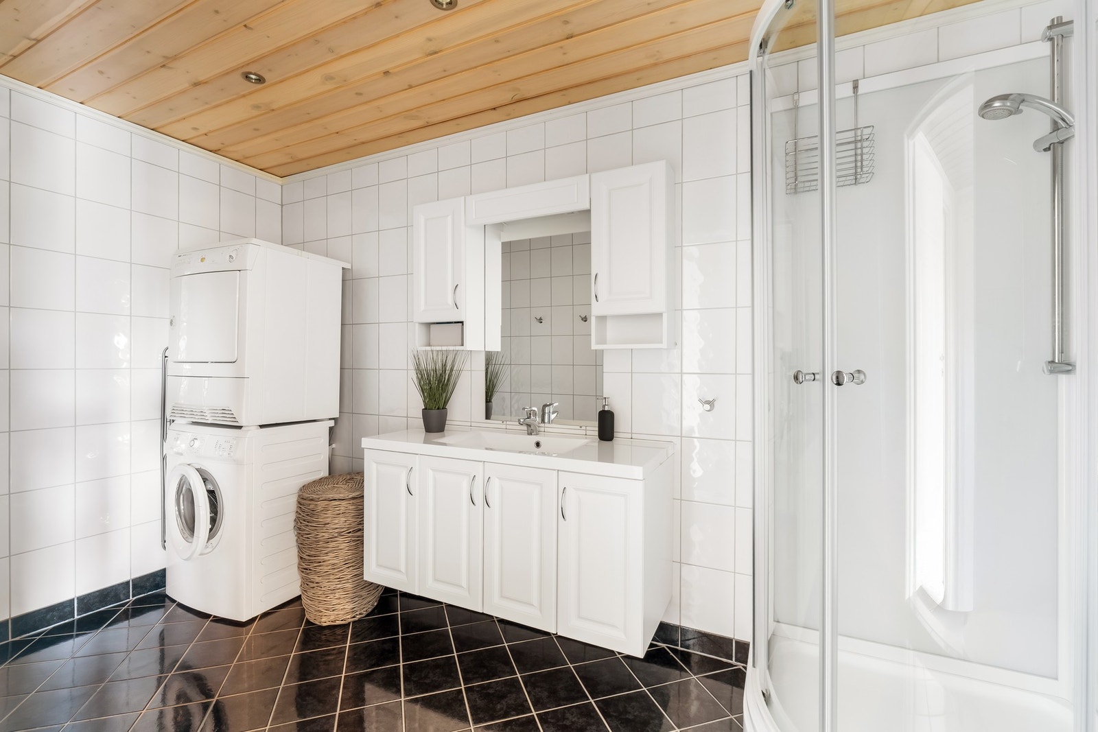 Badet i første etasje er utstyrt med vask, baderomsinnredning, toalett, dusjkabinett og opplegg for vaskemaskin. Galleribilde