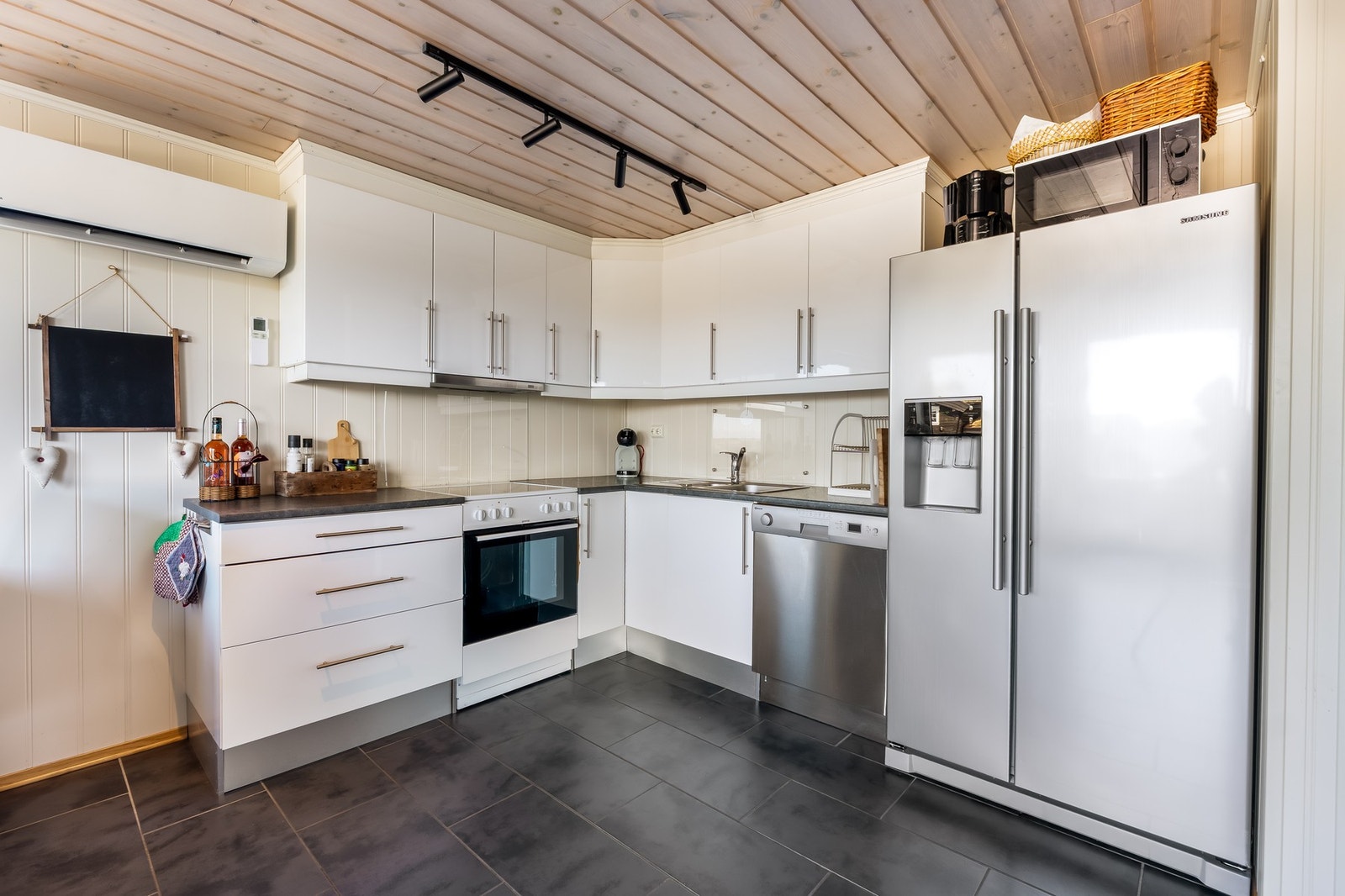 Kjøkkenet har folierte skrog med glatte fronter og laminat benkeplater, inkludert dobbel vask i stål. Galleribilde