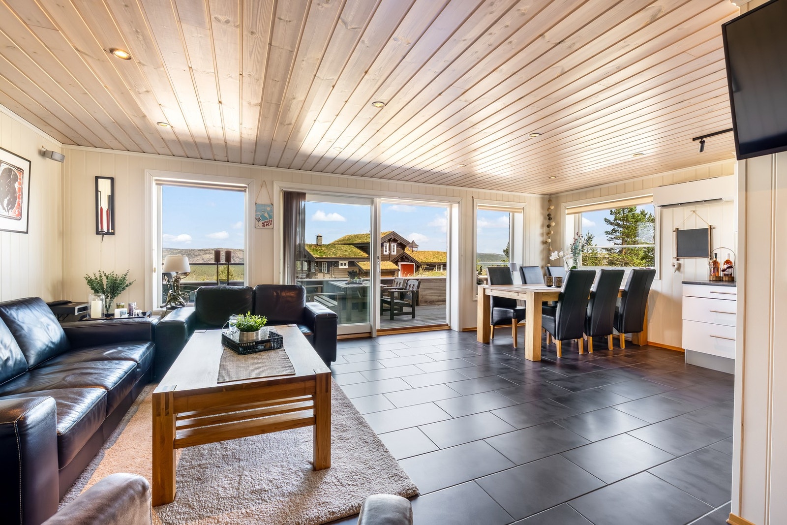 Åpen stue og kjøkkenløsning. Store vindusflater gir godt naturlig lys og sørger for en funksjonell opplevelse av rommet gjennom dagen. Galleribilde