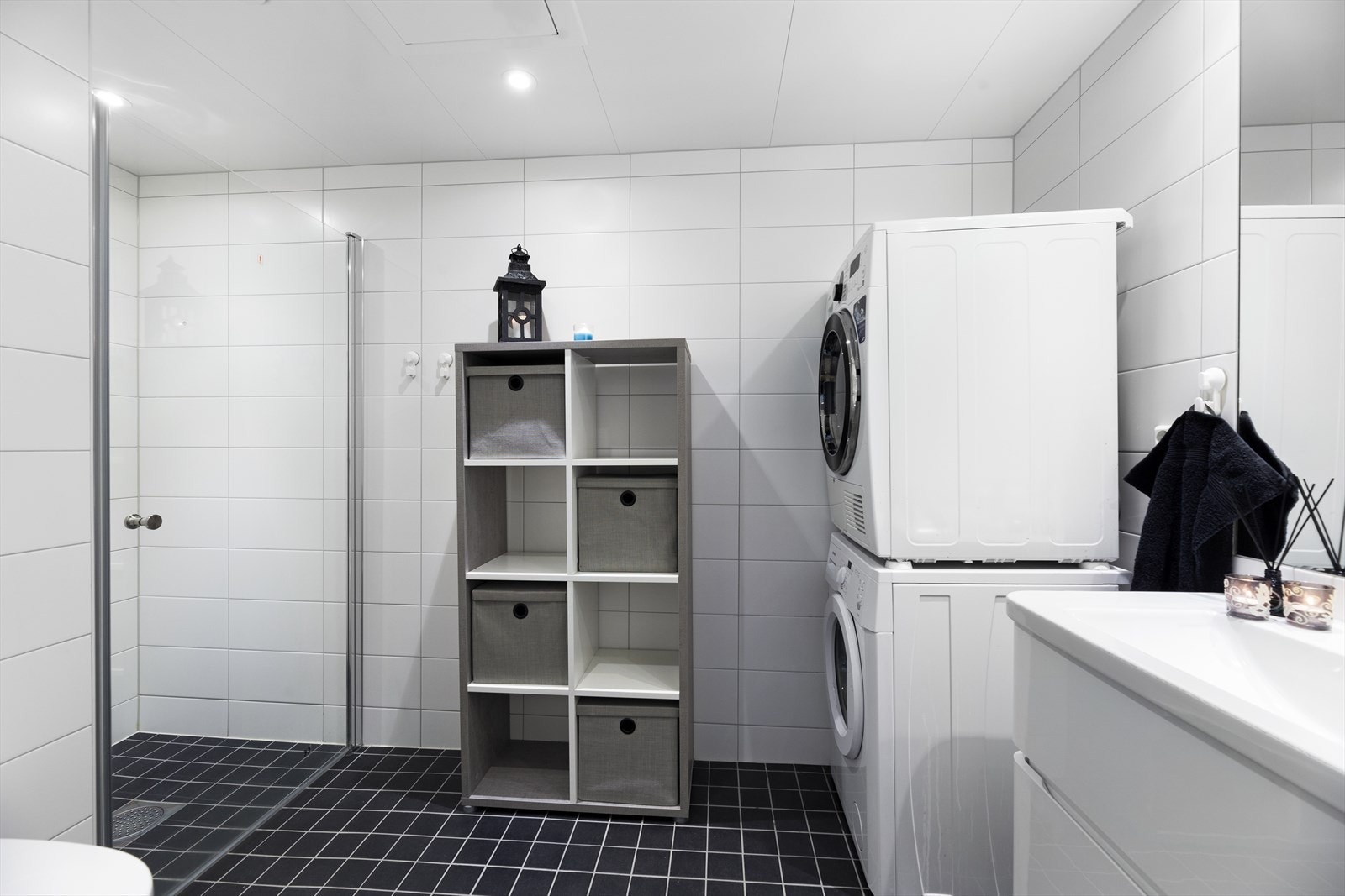 Badet i 2. etasje har baderomsinnredning med høyglansede fronter. Sanitærutstyr bestående av veggmontert klosett, servant, dusjhjørne og opplegg for vaskemaskin. Galleribilde