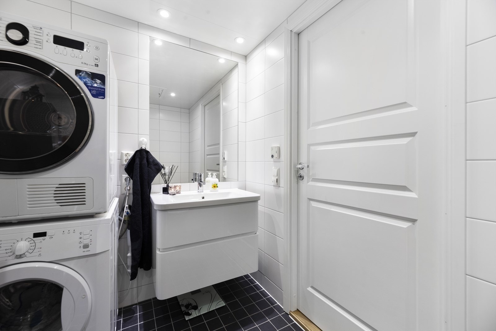 Baderomsinnredning i hvit utførelse med heldekkende servant og rom for oppbevaring i skuffeseksjon. Galleribilde