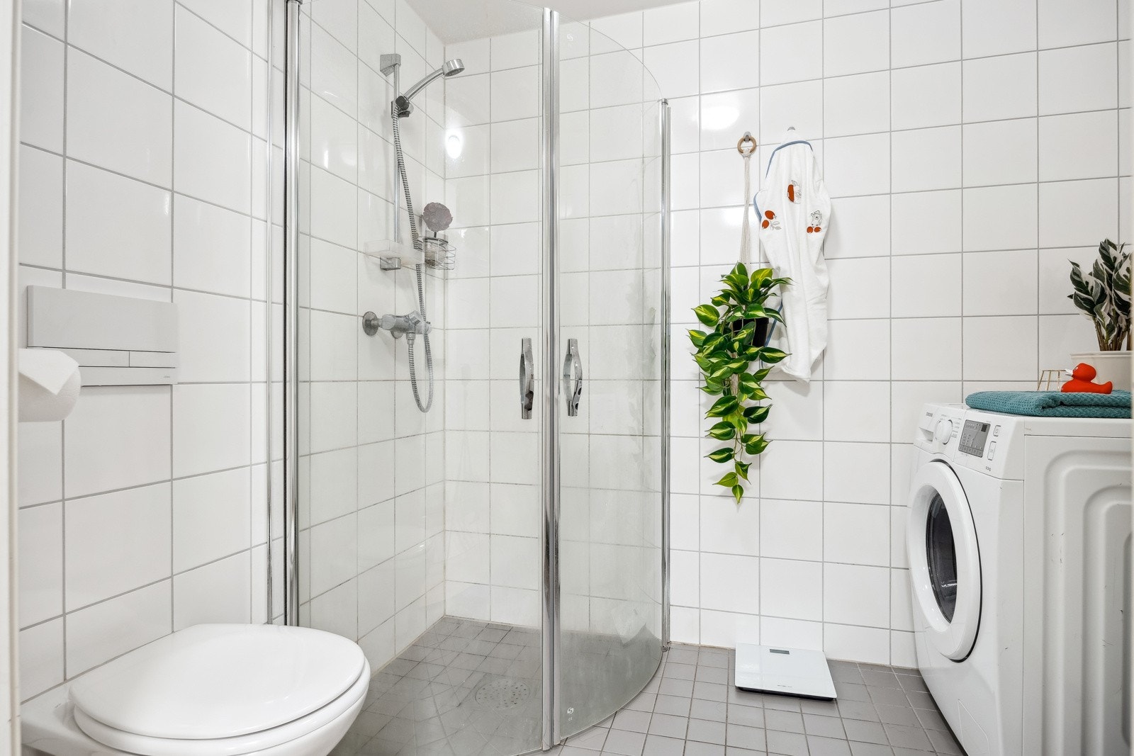 Dusjhjørne med innfellbare dører og vegghengt toalett for praktisk utnyttelse av plassen. Galleribilde