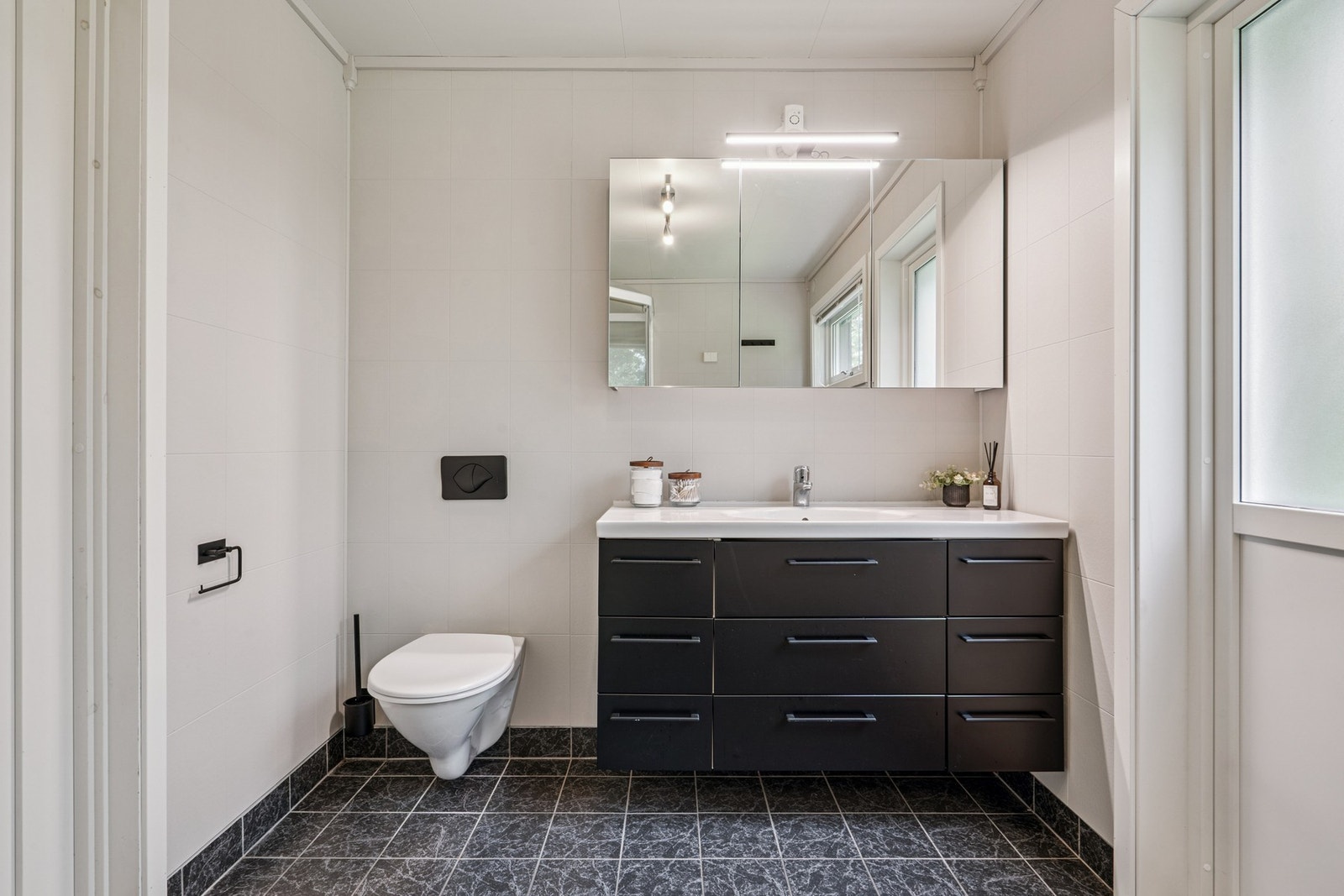 Rommet har innredning med nedfelt servant, speilskap med
belysning, veggmontert toalett med innebygget sisterne og
dusjkabinett. Galleribilde