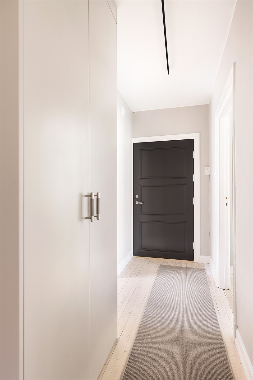 Lys og innbydende entré. Skap med spesiallagde dører med håndtak fra Buster and Punch Galleribilde