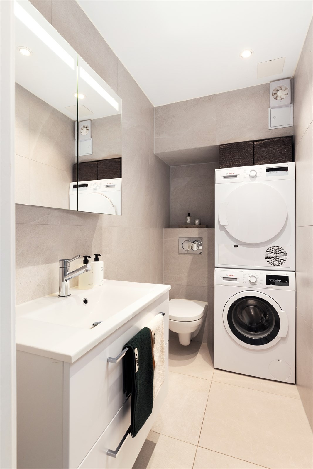 Lekkert helfliset bad fra 2020 utstyrt med servant i skap, vegghengt toalett, speilskap og opplegg for vaskemaskin. Gulvvarme og mekanisk avtrekk Galleribilde