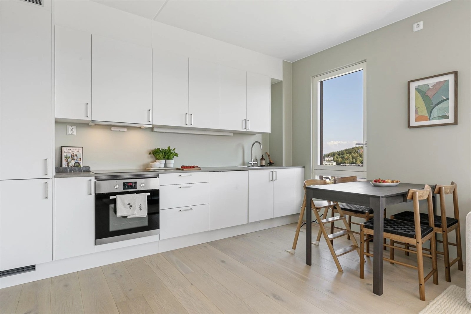 Moderne, lyst kjøkken med stilrene hvite skapfronter som gir et elegant og helhetlig uttrykk. Galleribilde